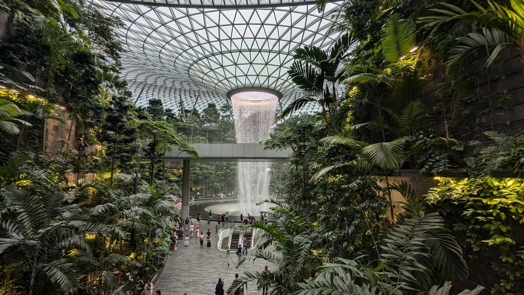 Shiseido Forest Valley and Rain Vortex waterfall inside Jewel Changi Airport Singapore surrounded by indoor rainforest and glass dome ceiling