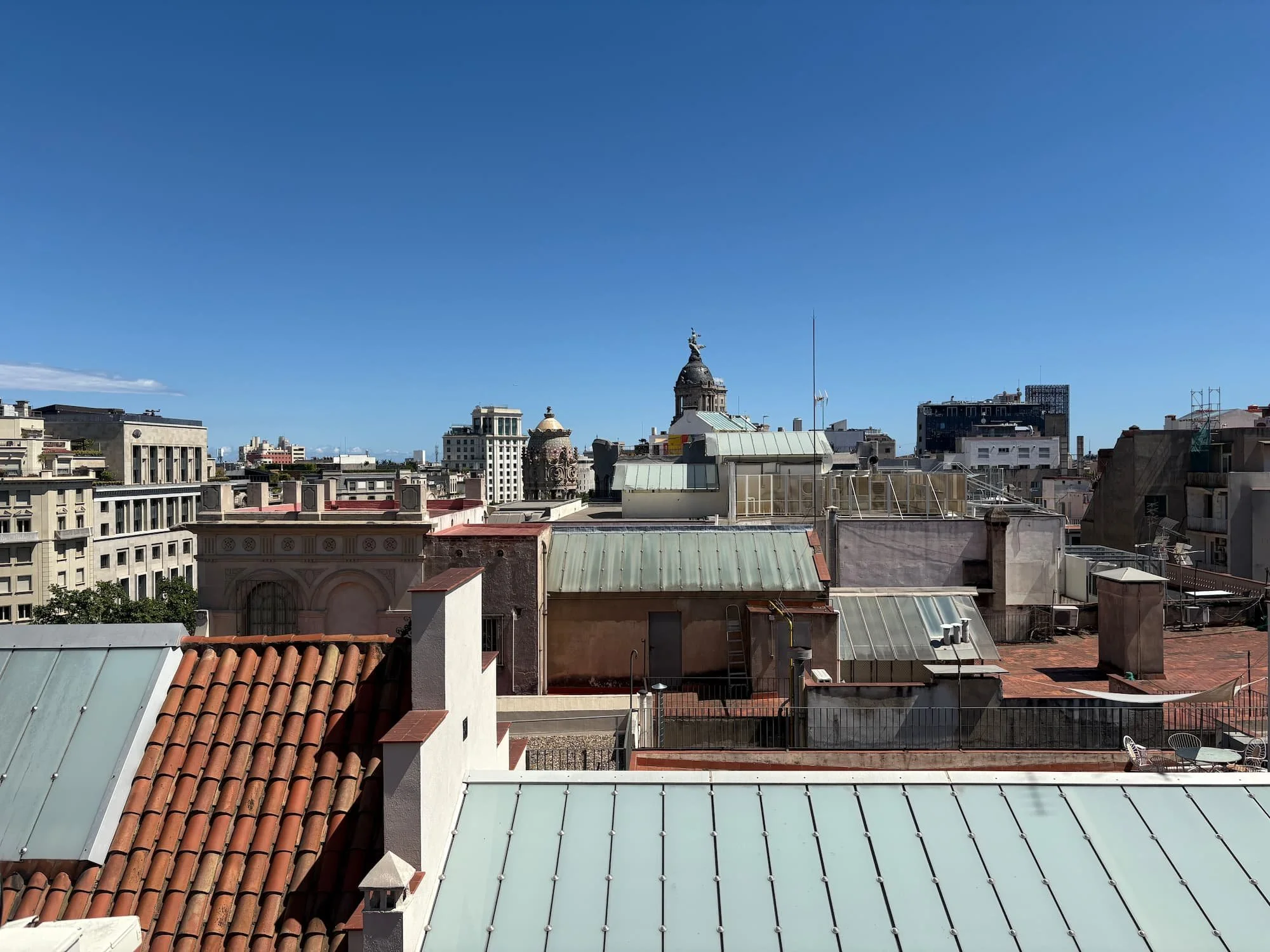 View across the Barcelona skyline from the rooftop terrace of Casa Batlló on a sunny day.