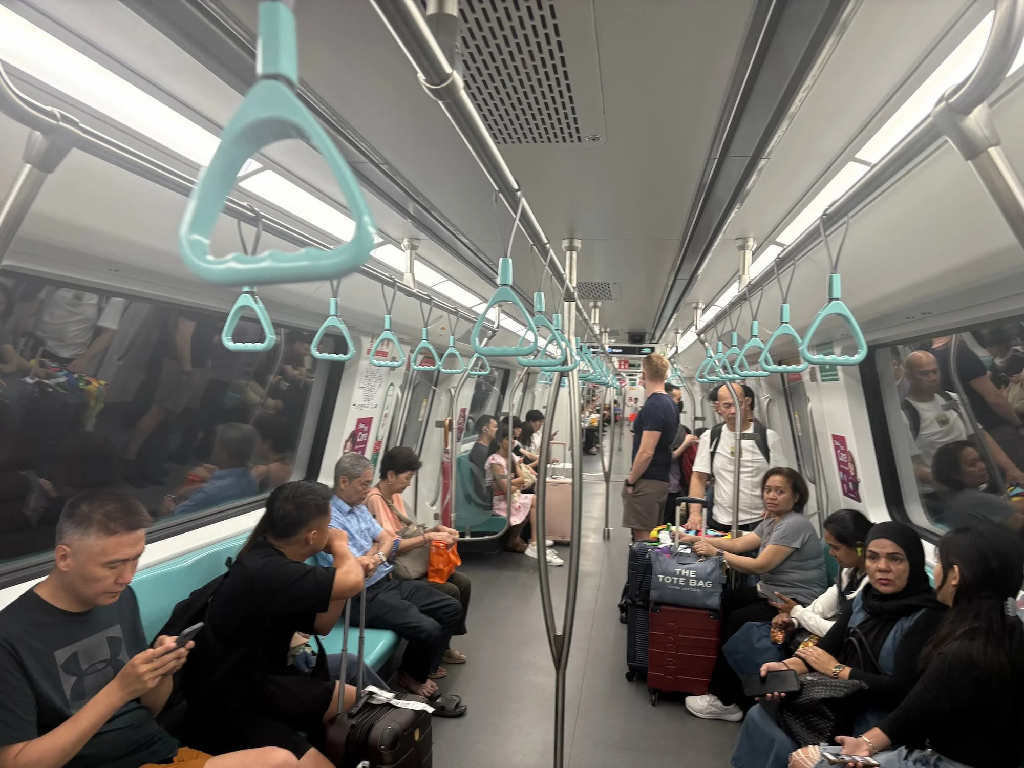 Interior of a Singapore MRT train showing passengers seated and standing, highlighting the city’s efficient public transport system