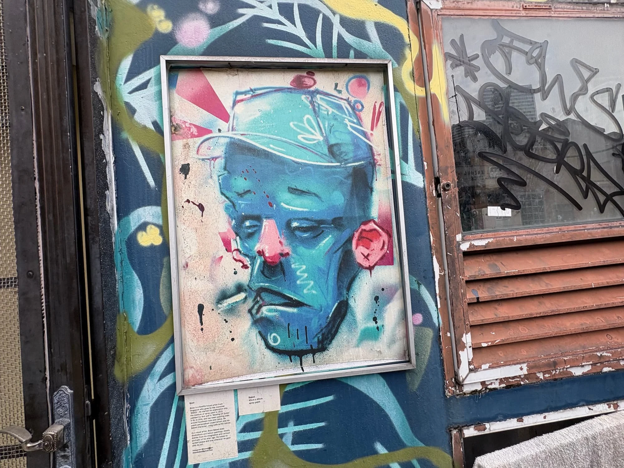 Colourful street art portrait mural in Kampong Glam Singapore on a historic shophouse wall