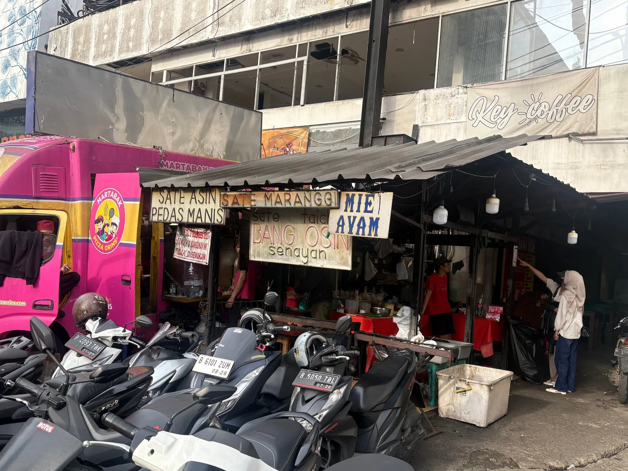 Street food stall in Indonesia with local menu signs showing need for translation using eSIM data