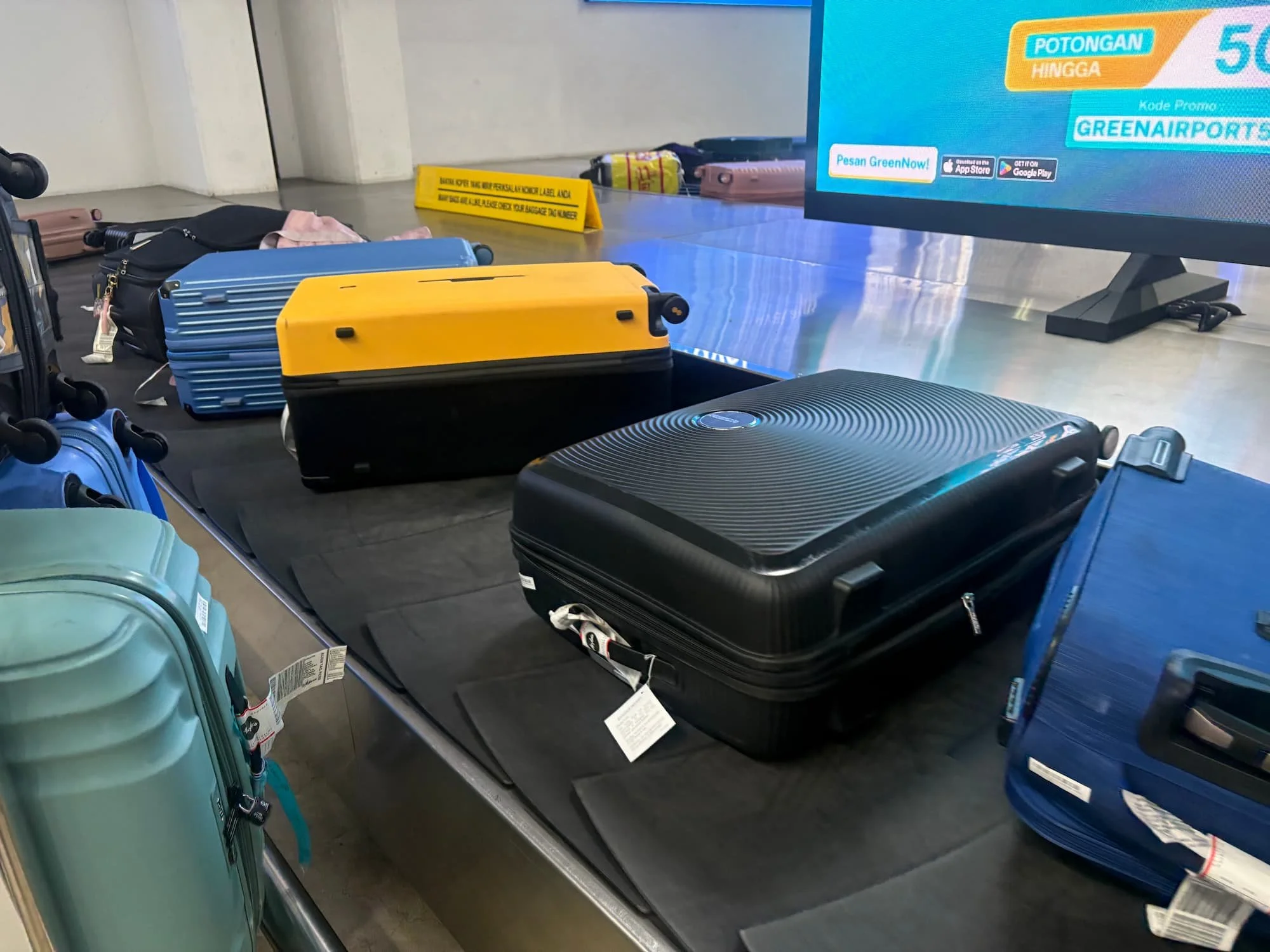 Yellow Level8 Voyageur suitcase on Airport luggaeg carousel