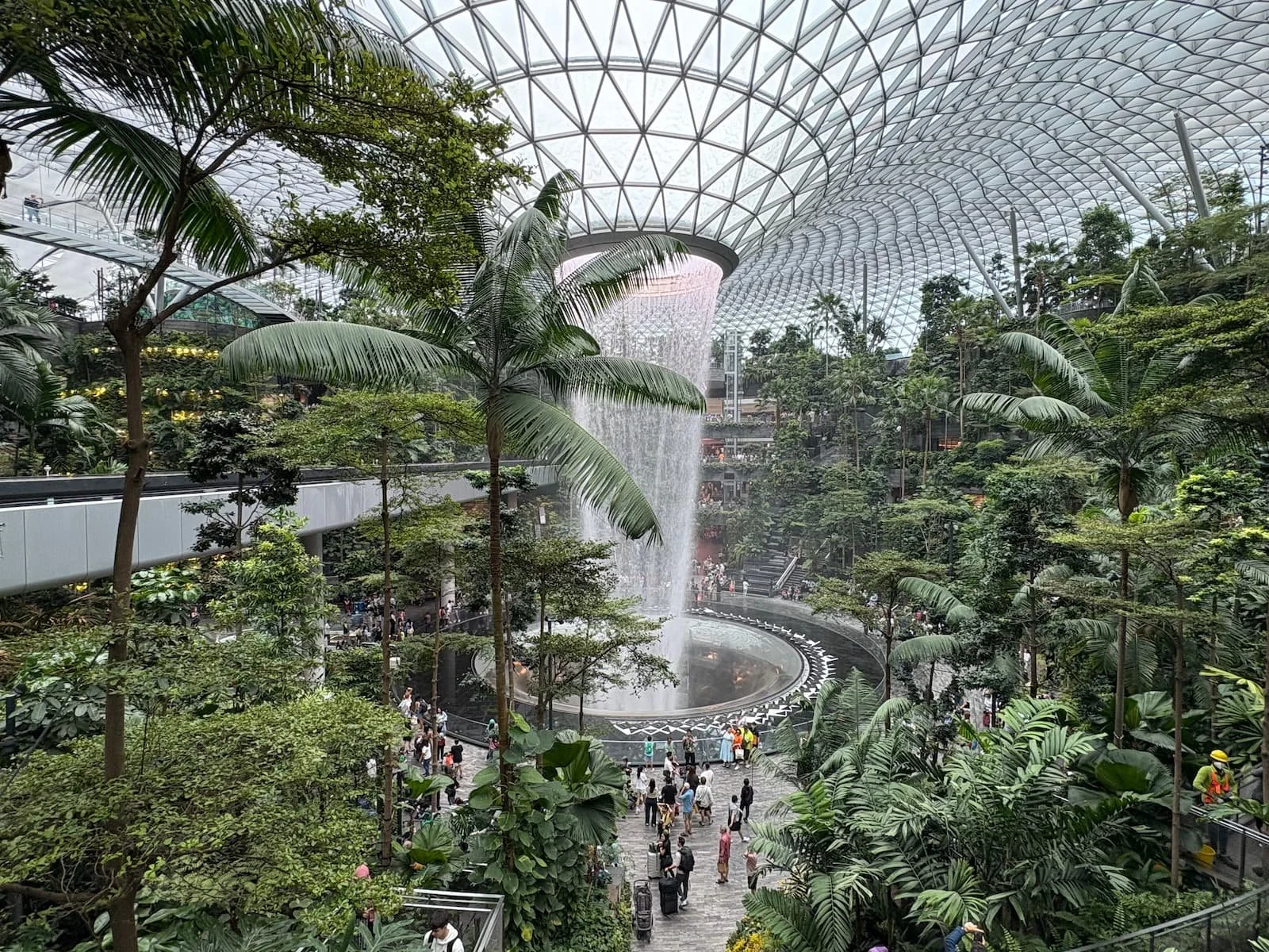 Rain Vortex waterfall inside Jewel Changi Airport Singapore surrounded by indoor rainforest and glass dome roof
