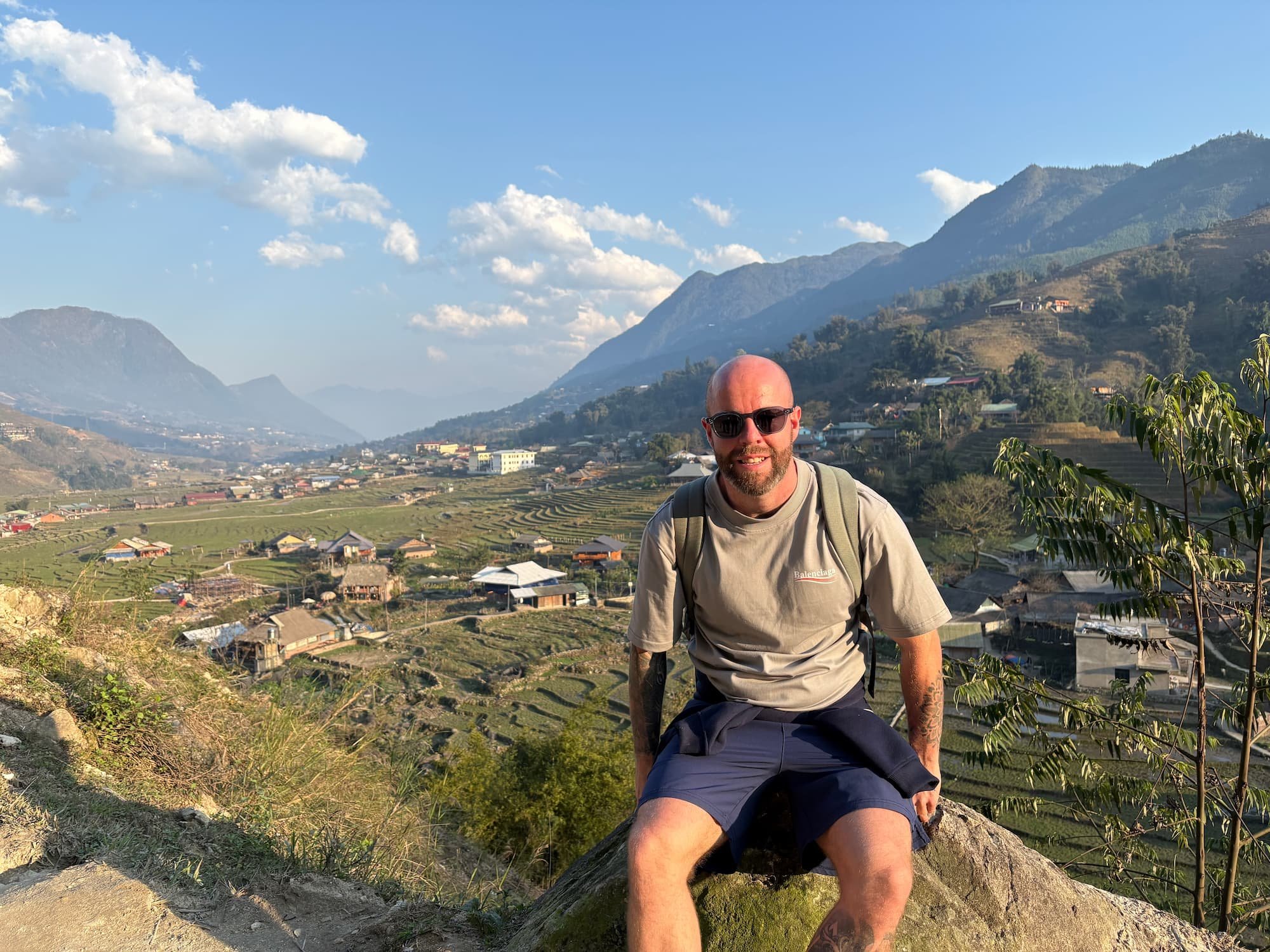 Tom Henty sat in Sapa with amazing backdrop of mountains and valley
