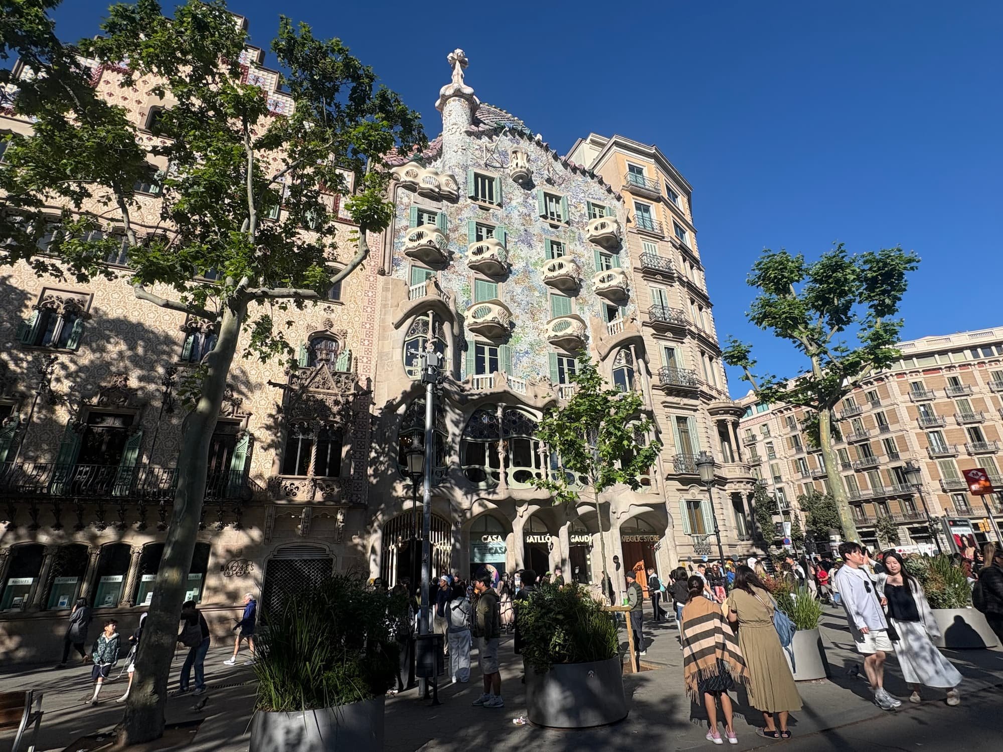 Casa Batlló façade on Passeig de Gràcia in Barcelona, featuring Gaudí's colourful mosaic exterior, curved balconies and dragon-inspired rooftop