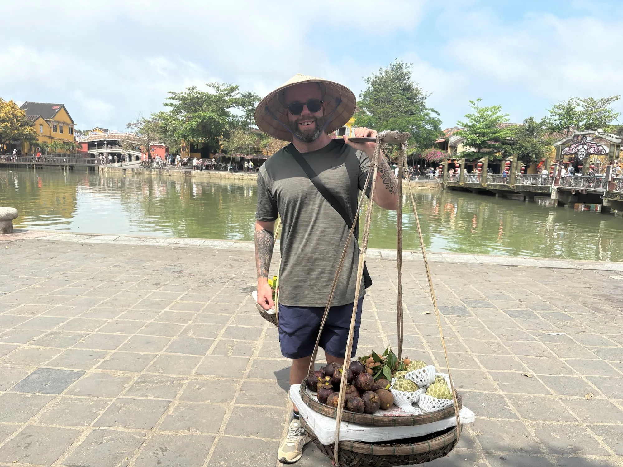 Tom Henty posing as a fruit seller in Hoi An in VIetnam