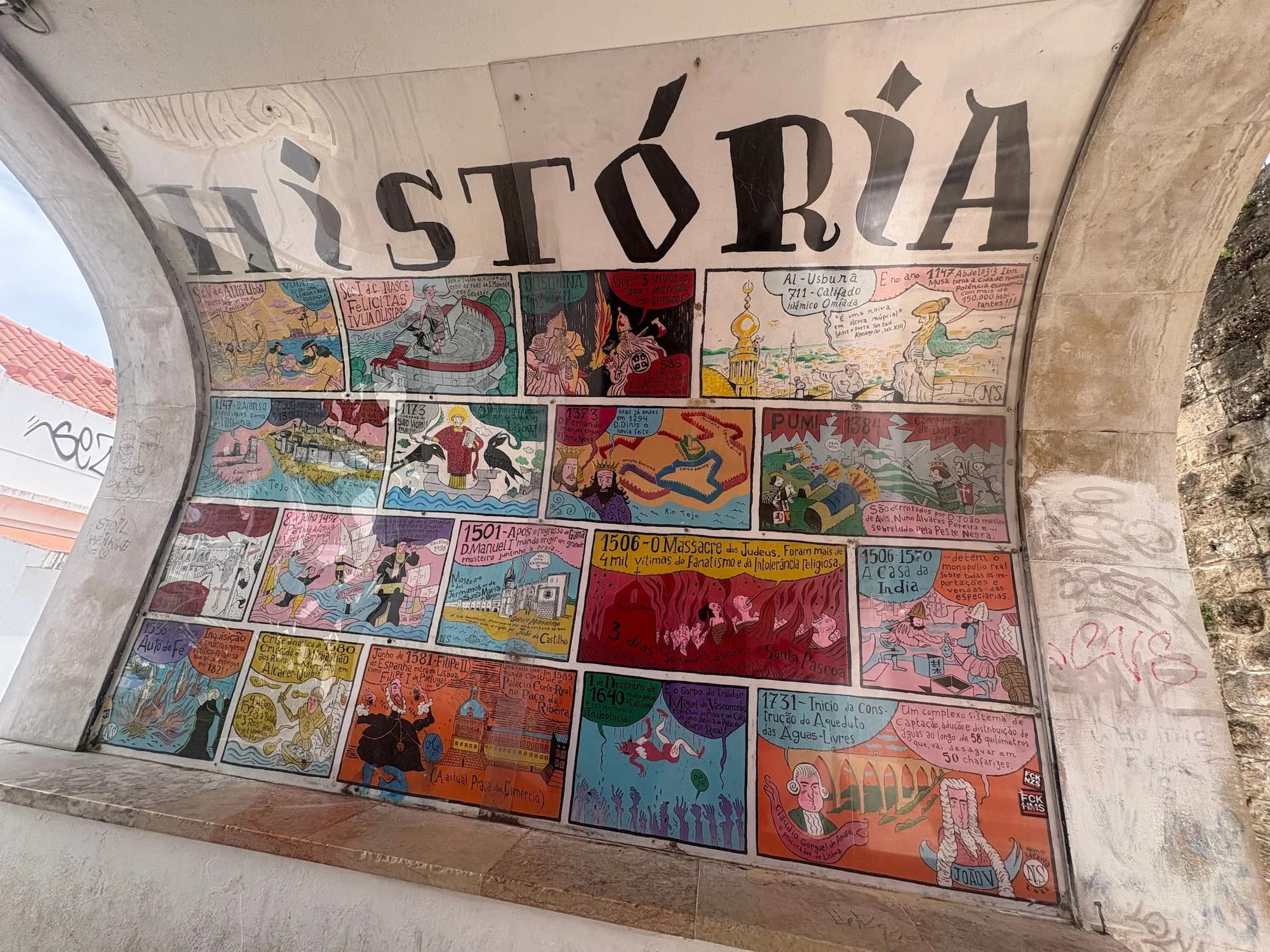 Colourful illustrated mural depicting scenes from Lisbon's history, displayed beneath a historic archway in the Portuguese capital.