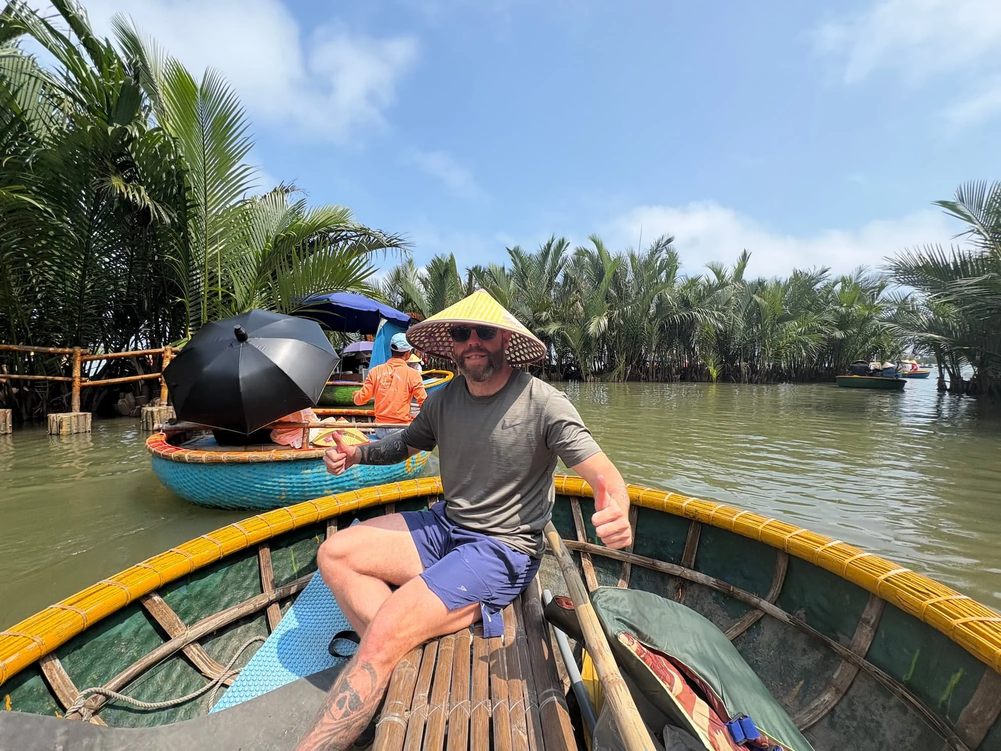 Tom Henty wearing straw hat on basket boat tour near Hoi An in Vietnam