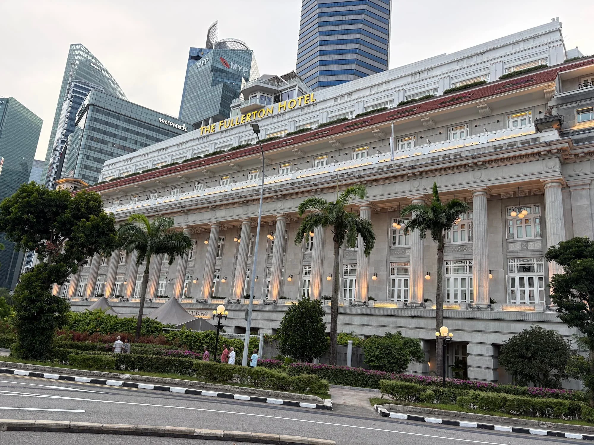 The Fullerton Hotel framed by palm trees in Singapore