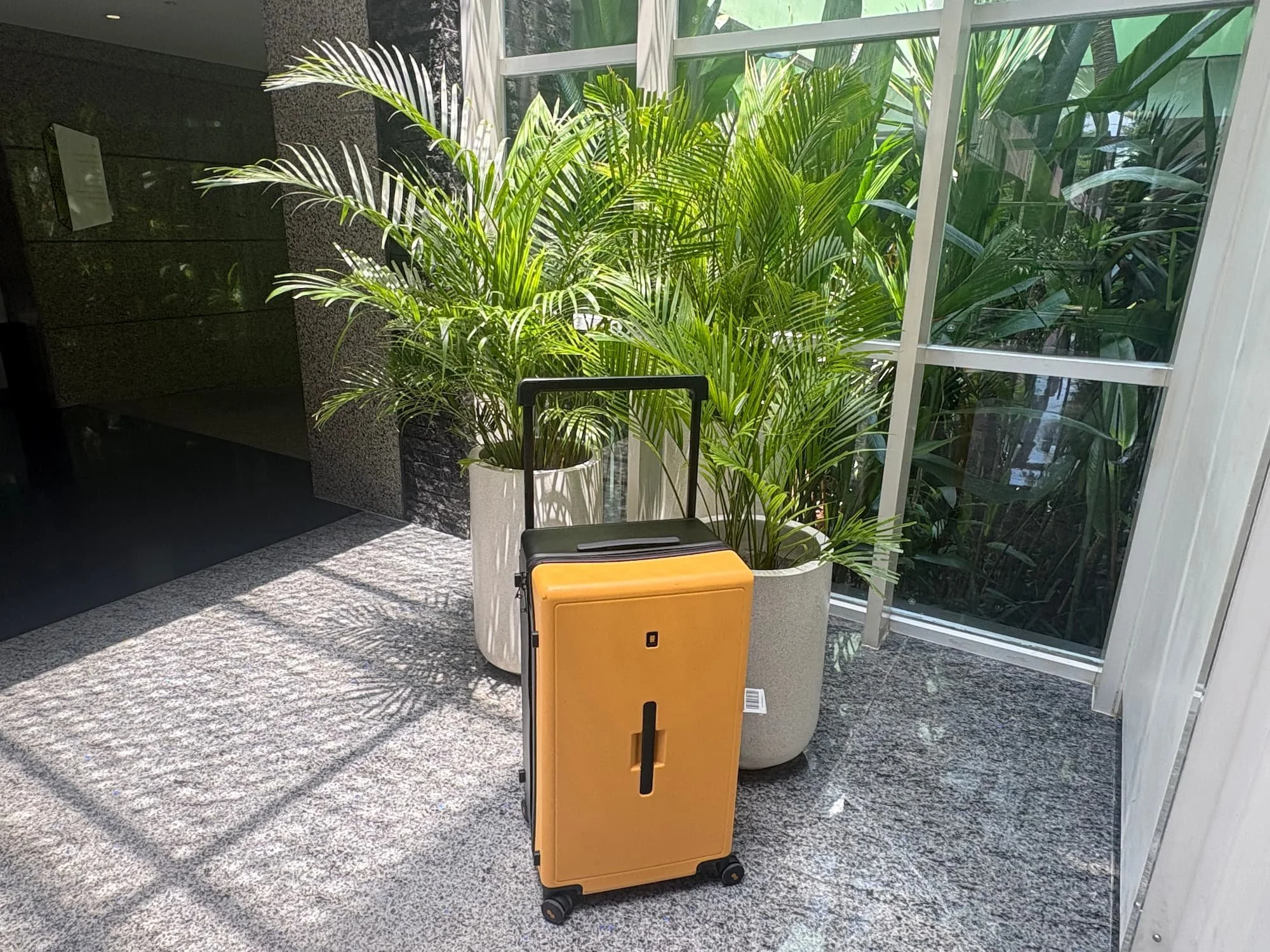 Level 8 Voyageur Suitcase next to plants in a modern hotel in Jakarta