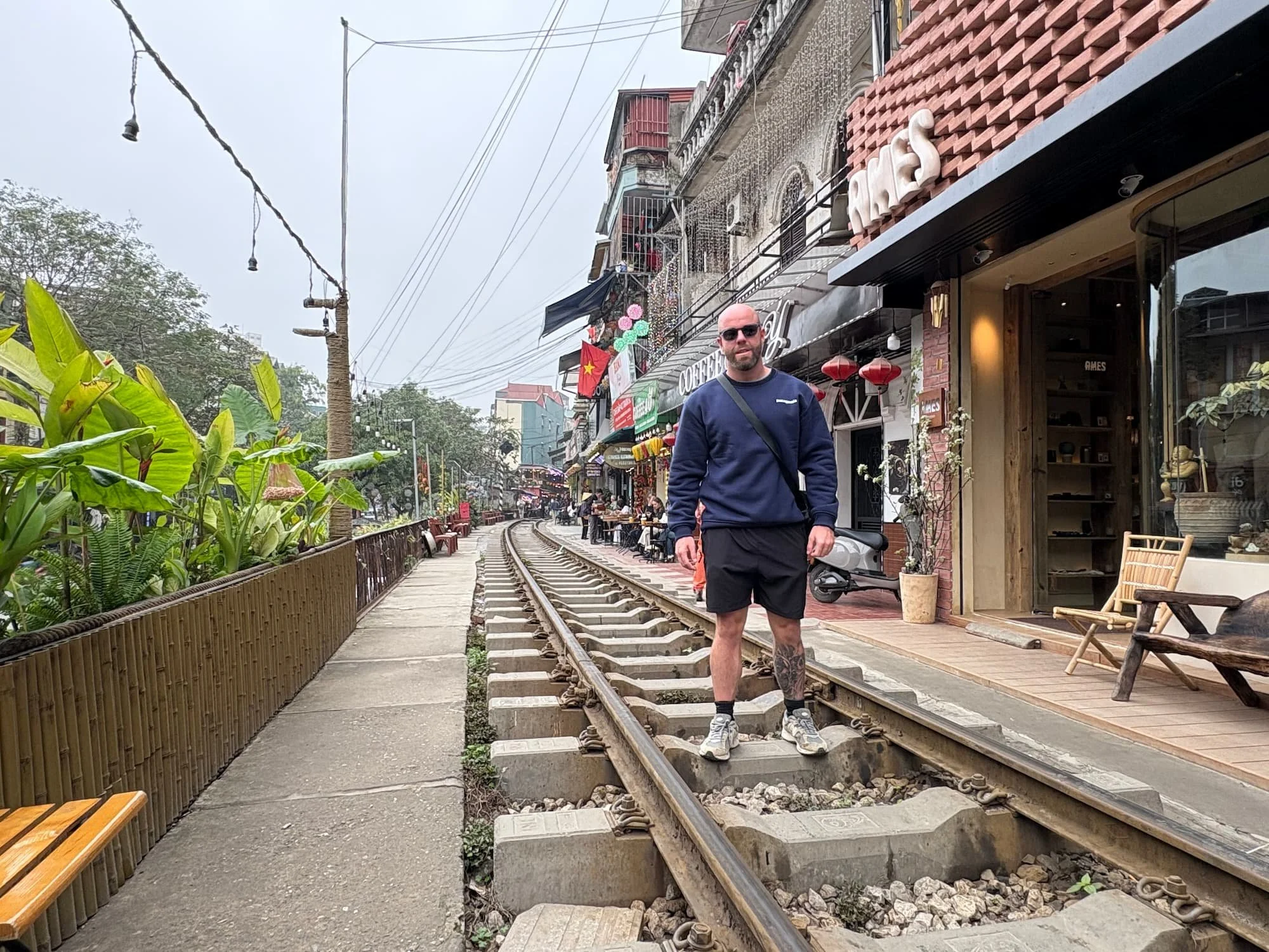 Tom Henty stood on tracks at Hanoi Train Street in Vietnam