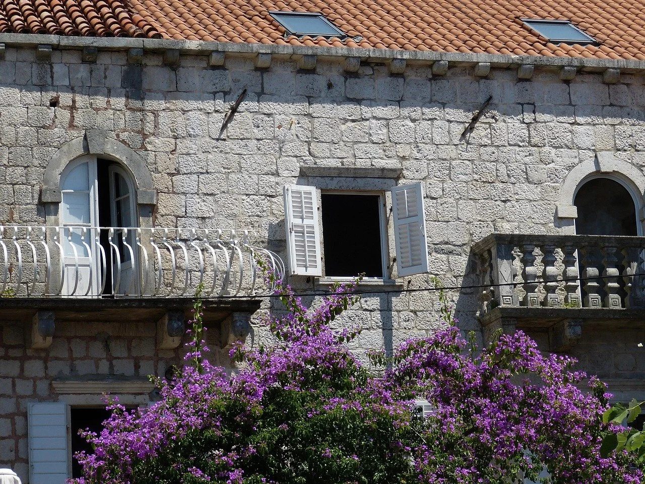 A stone building with colourful flowers outside in Perast in Kotor in Montenegro