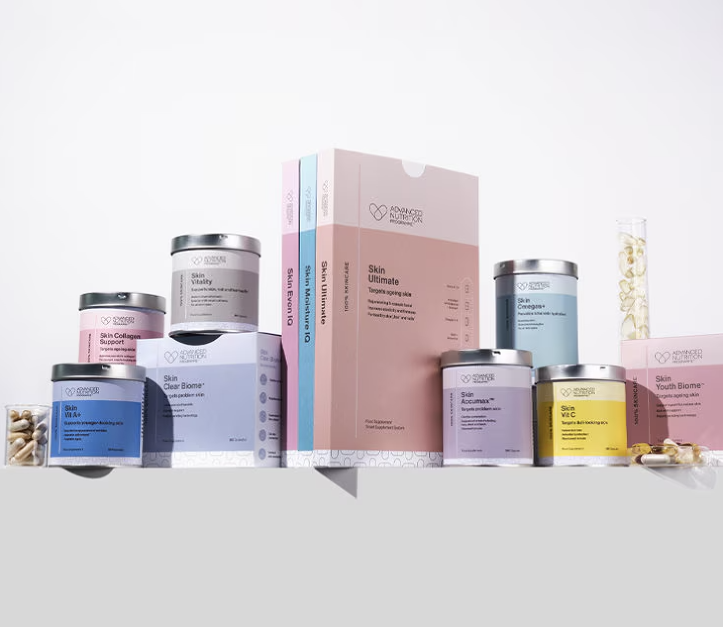 Assorted skincare supplement containers and boxes on a plain background.