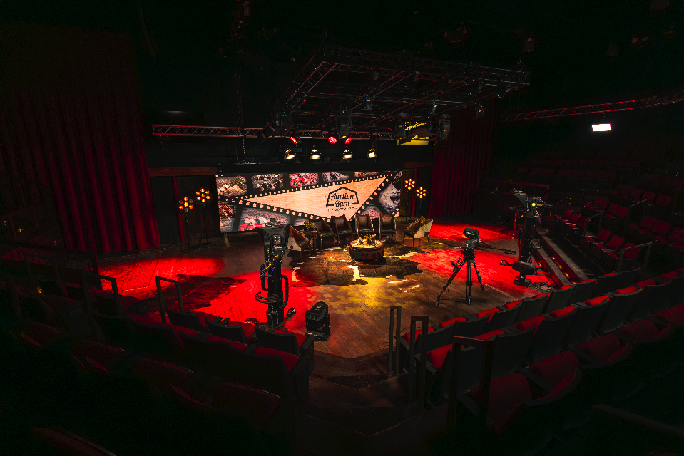 Empty theater stage with chairs, cameras, and lights ready for a show or event.