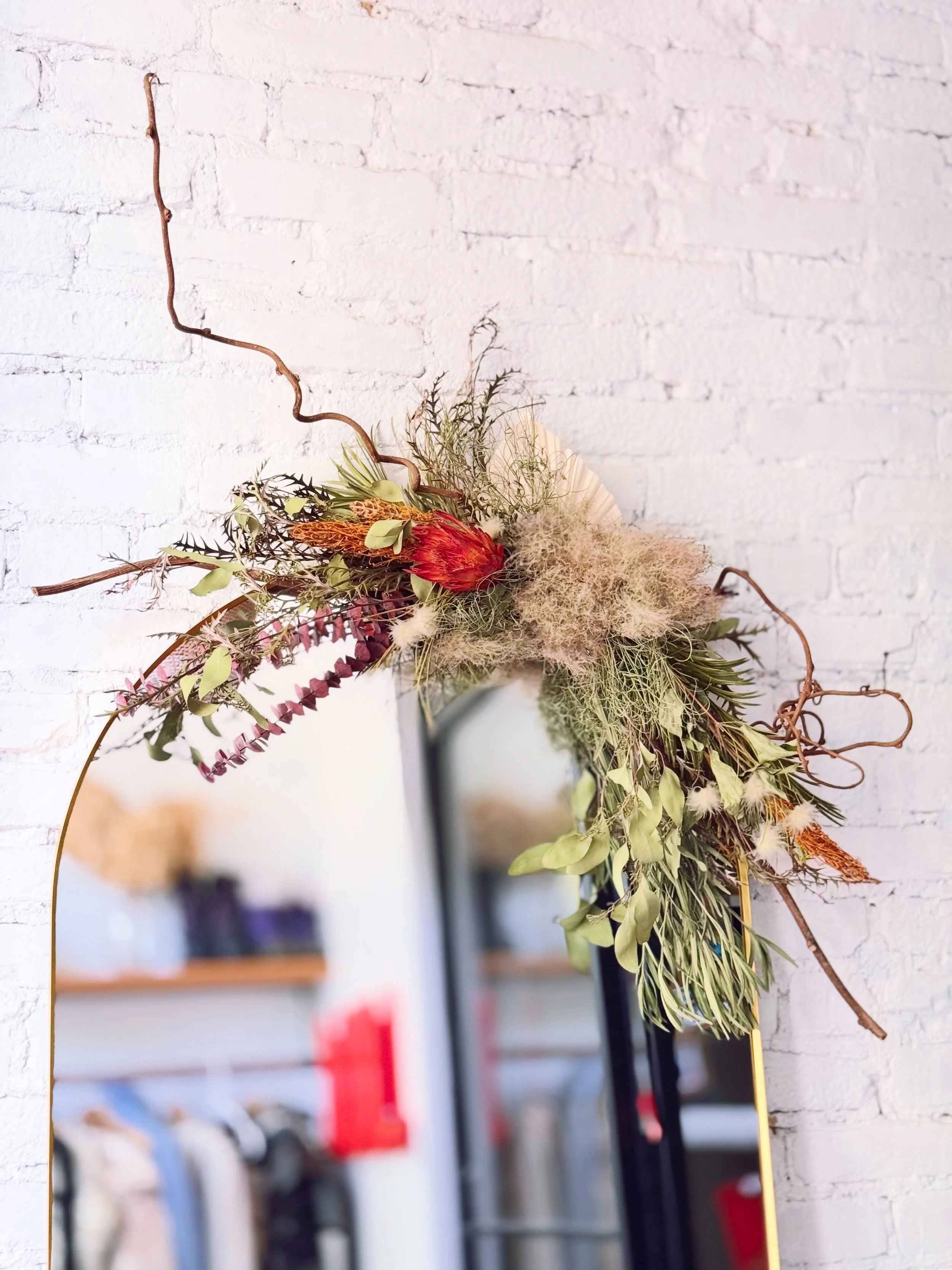 Wall Hanging Arrangement 🌿❤️

Made with lush greenery, kiwi vine, red protea and smoke tree, this wall hanging arrangement came together so beautifully❤️

Whether displayed beside a framed painting or above a wall mirror, it complements its surround