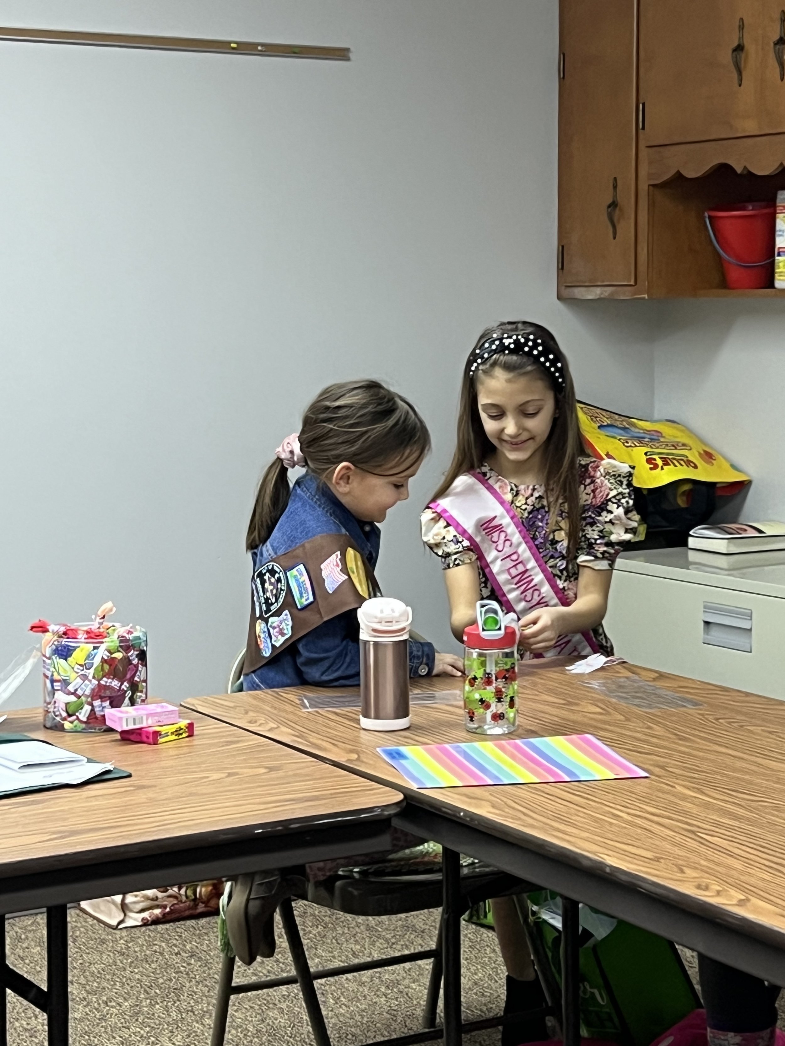 Teaching Girl Scouts how to make friendship bracelets for the bracelet drive.