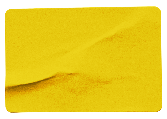 A close-up of a yellow sticky note with a torn edge, showing some folds and texture.