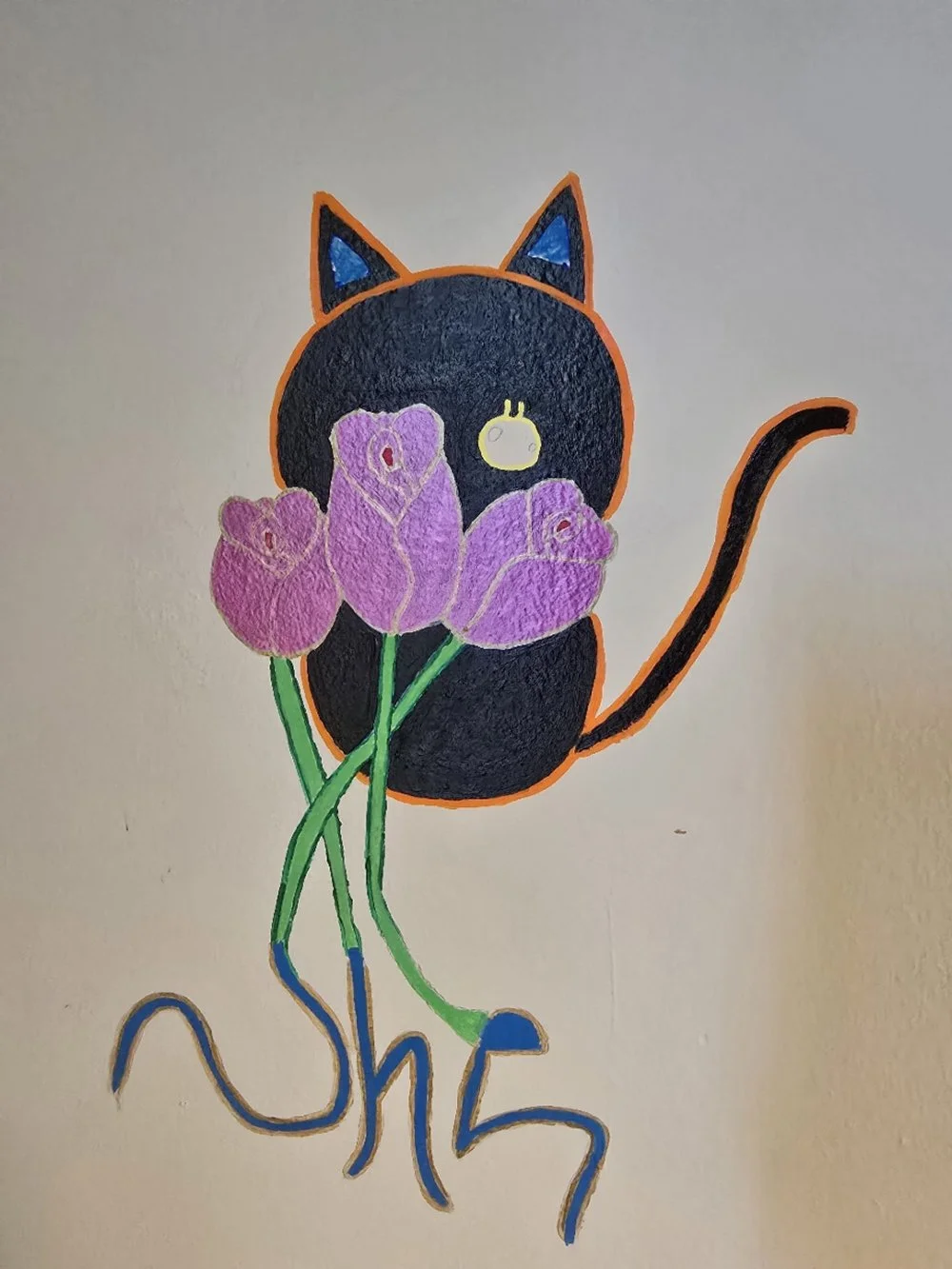 A black cat hiding behind three pink roses