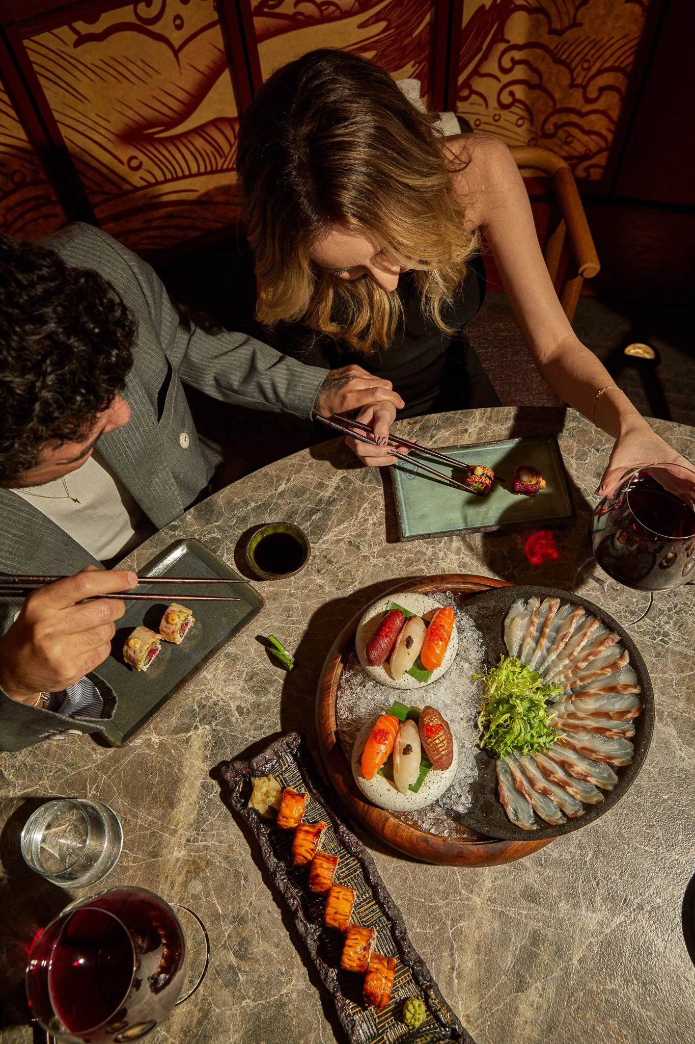 Restoran lifestyle çekimi - Üst açıdan sushi tabağı ve şarap eşleşmesi.