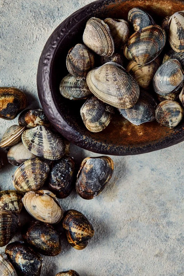 Dokulu bir yüzeyde kase içinde midye.