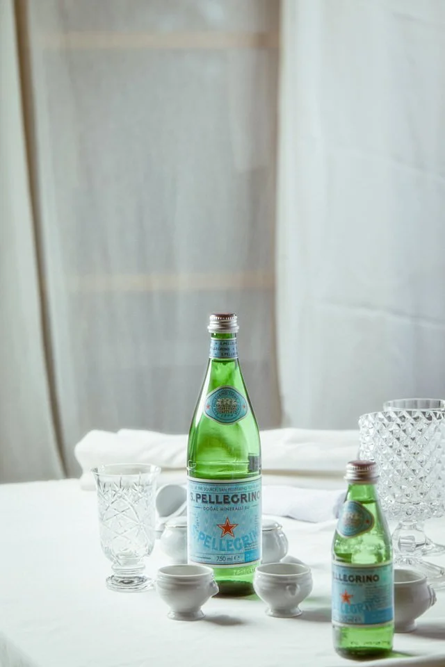 Istakoz risottosu, yanında içecek şişesi, mum ve bardaklarla tamamlanmış şık bir masa düzeni.

