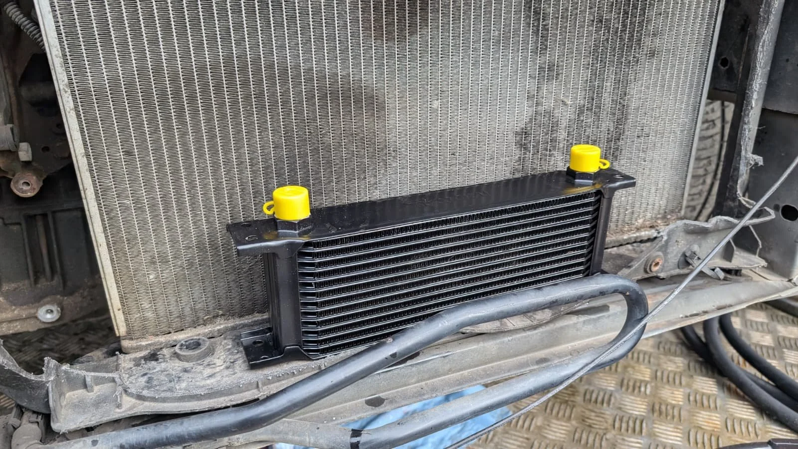 Car radiator and oil cooler mounted inside a vehicle's front compartment.