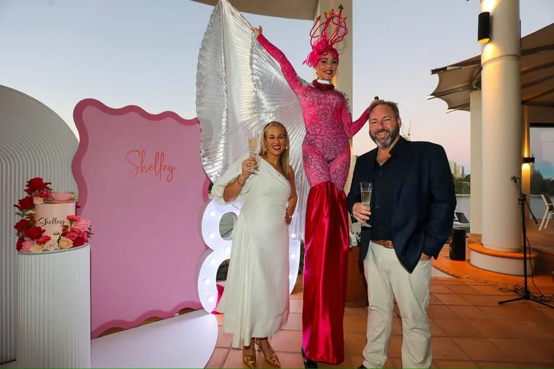 Pink stilt walker pouring champagne private party Gold Coast