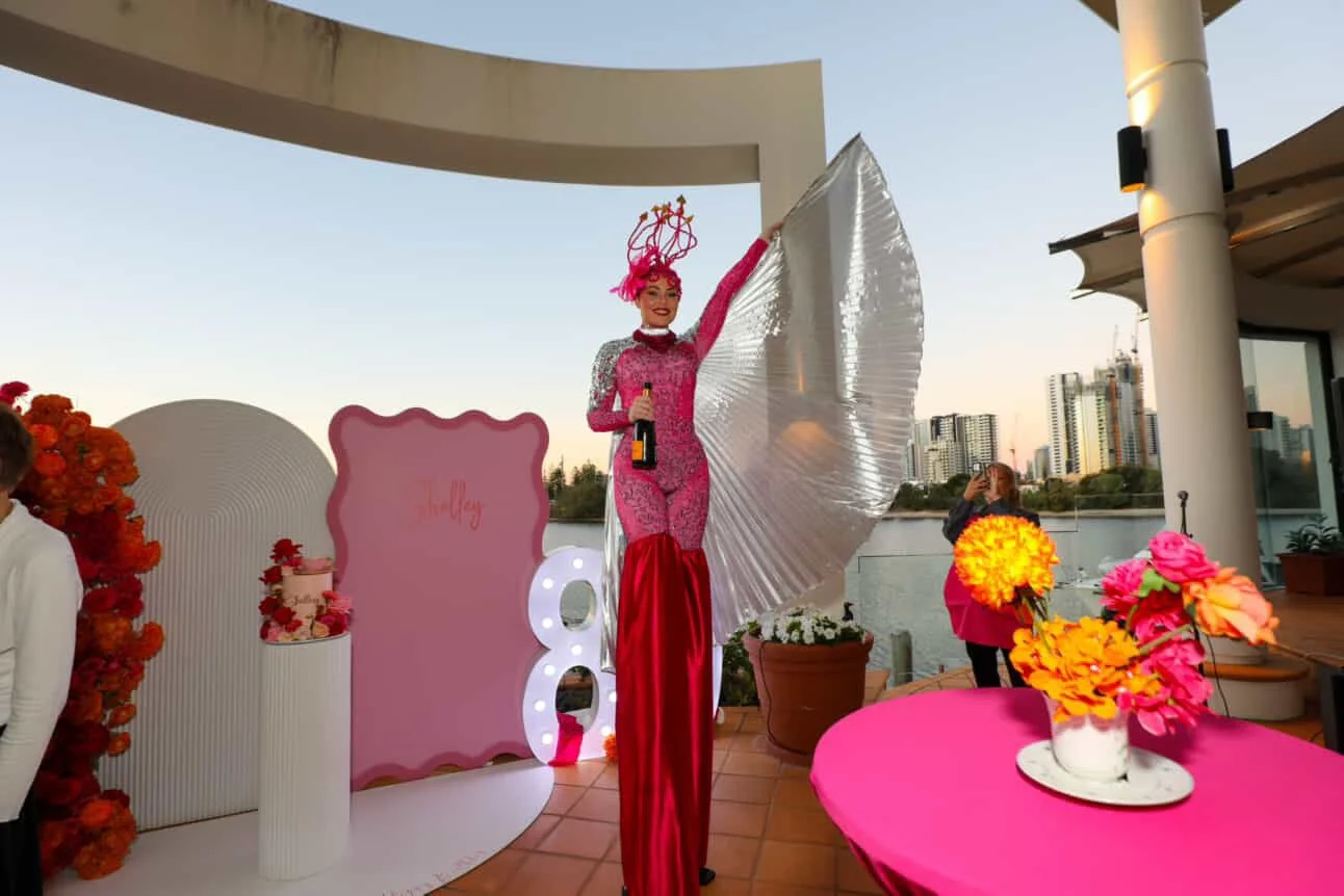 Pink stilt walker pouring champagne private party Gold Coast