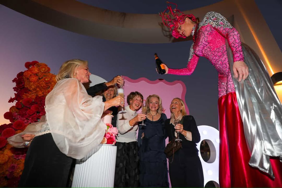 Pink stilt walker pouring champagne private party Gold Coast