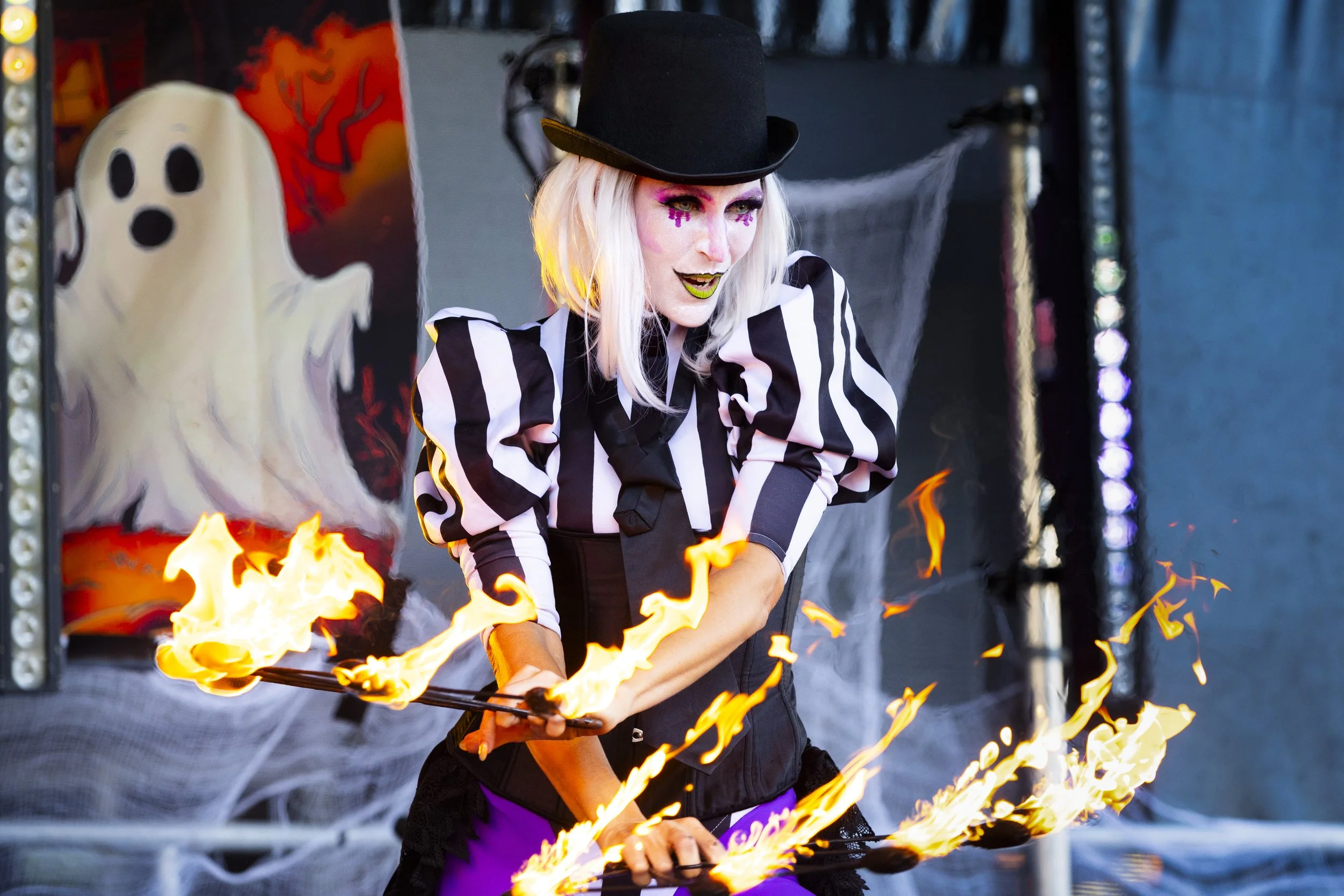Fire juggling performer in theatrical Halloween costume at live event