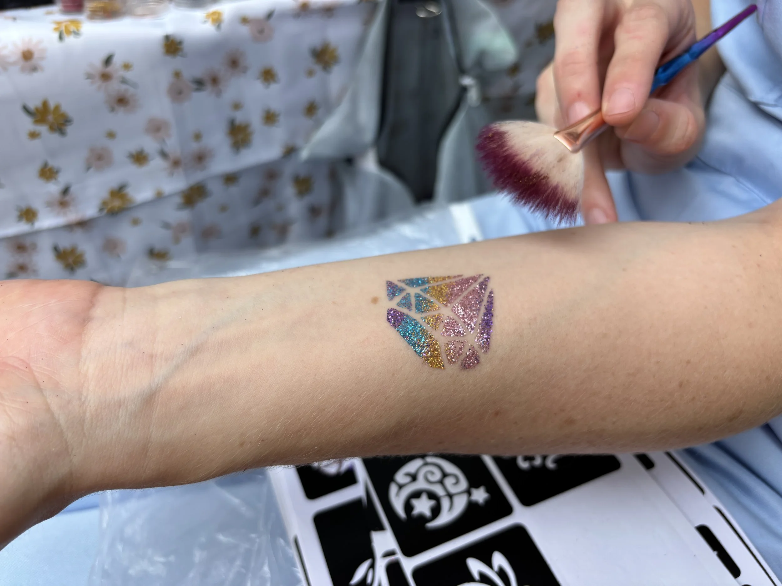 Glitter tattoo station adding colour and engagement to Brisbane corporate family days.
