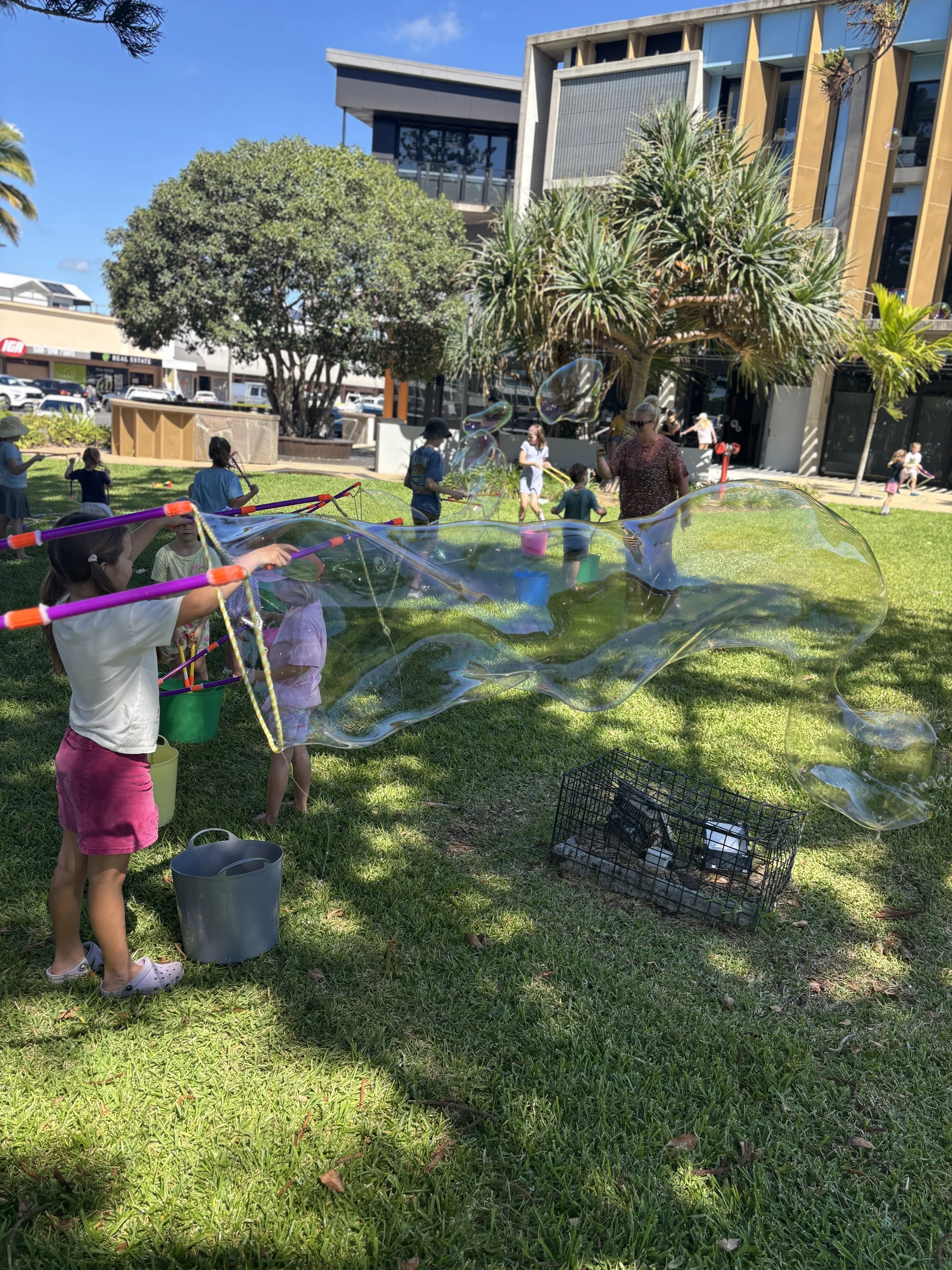 Children making giant bubbles at a school fete bubble play space