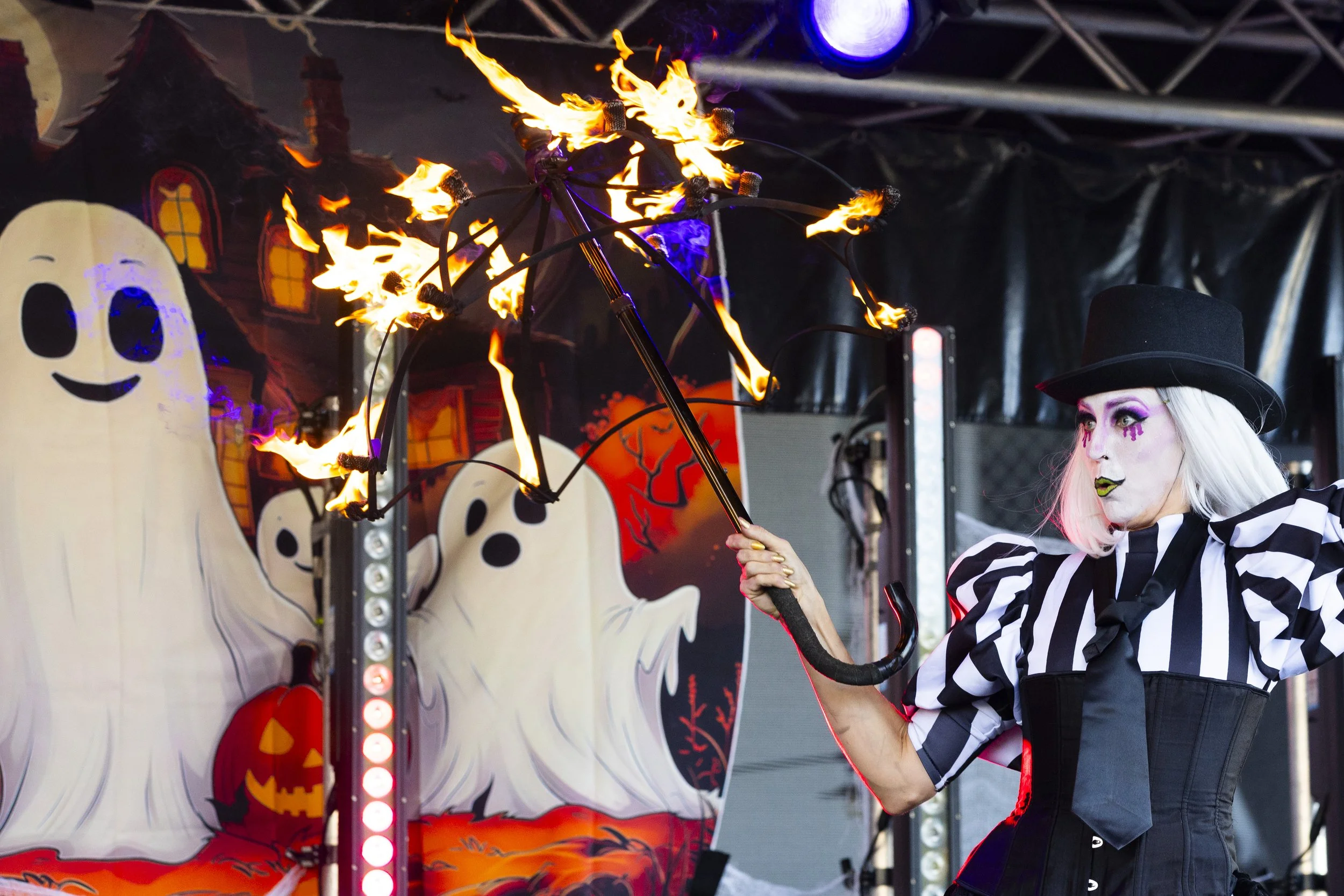 Festival fire show performer in spooky costume for Halloween entertainment