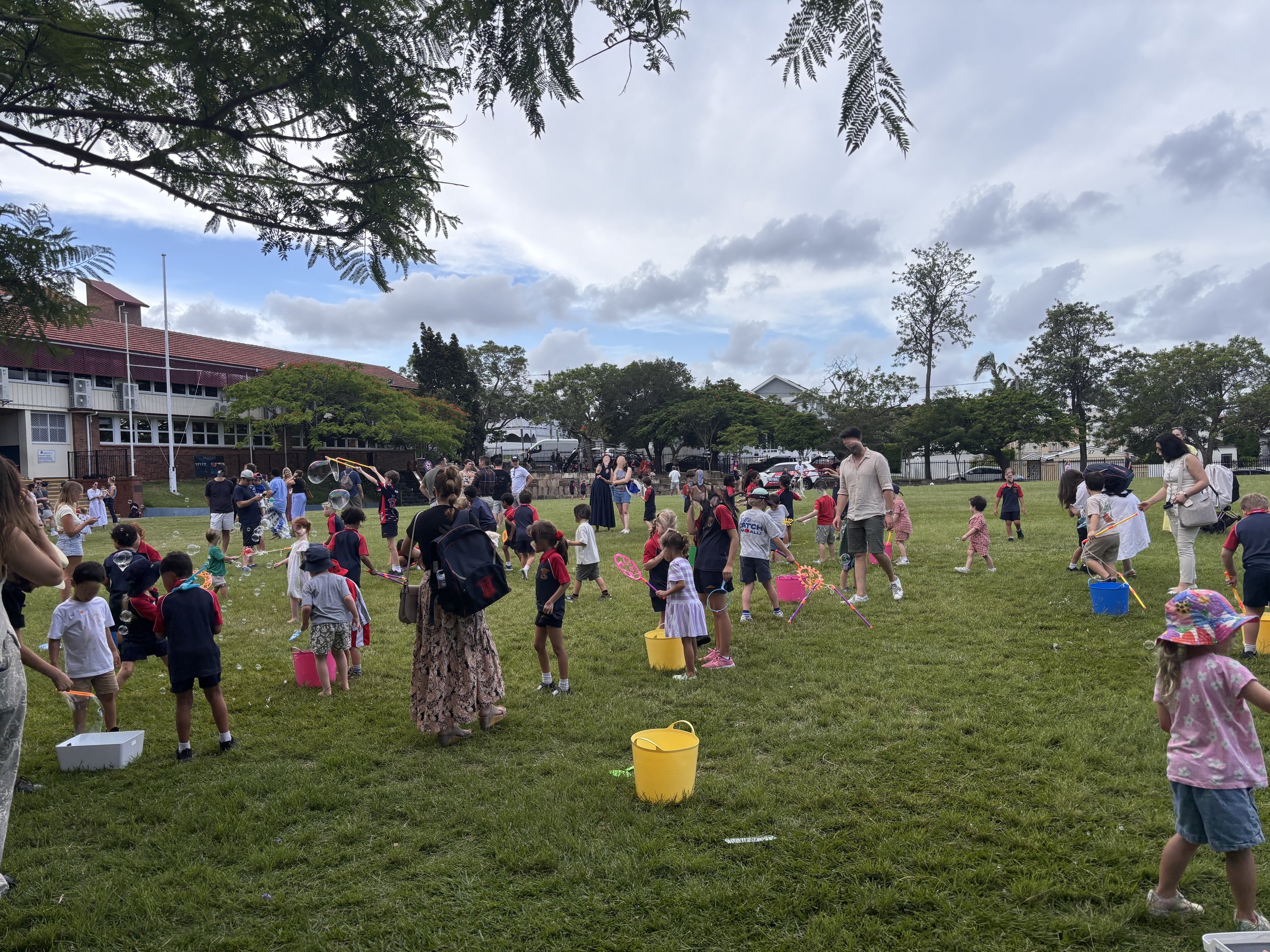 Outdoor children’s bubble play space with giant bubbles floating across the grass
