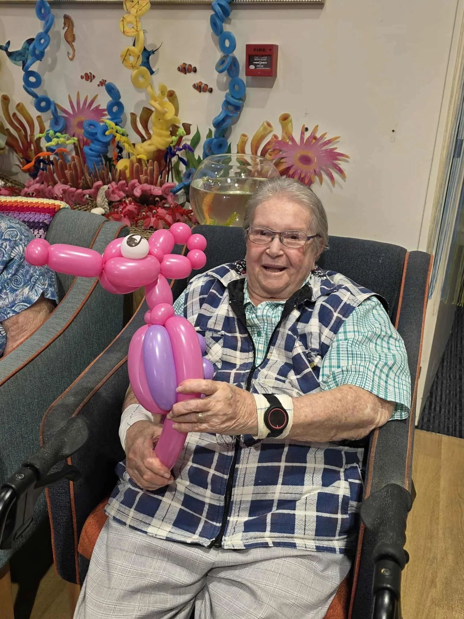Friendly balloon twisting creating animal shapes for seniors events across Queensland.