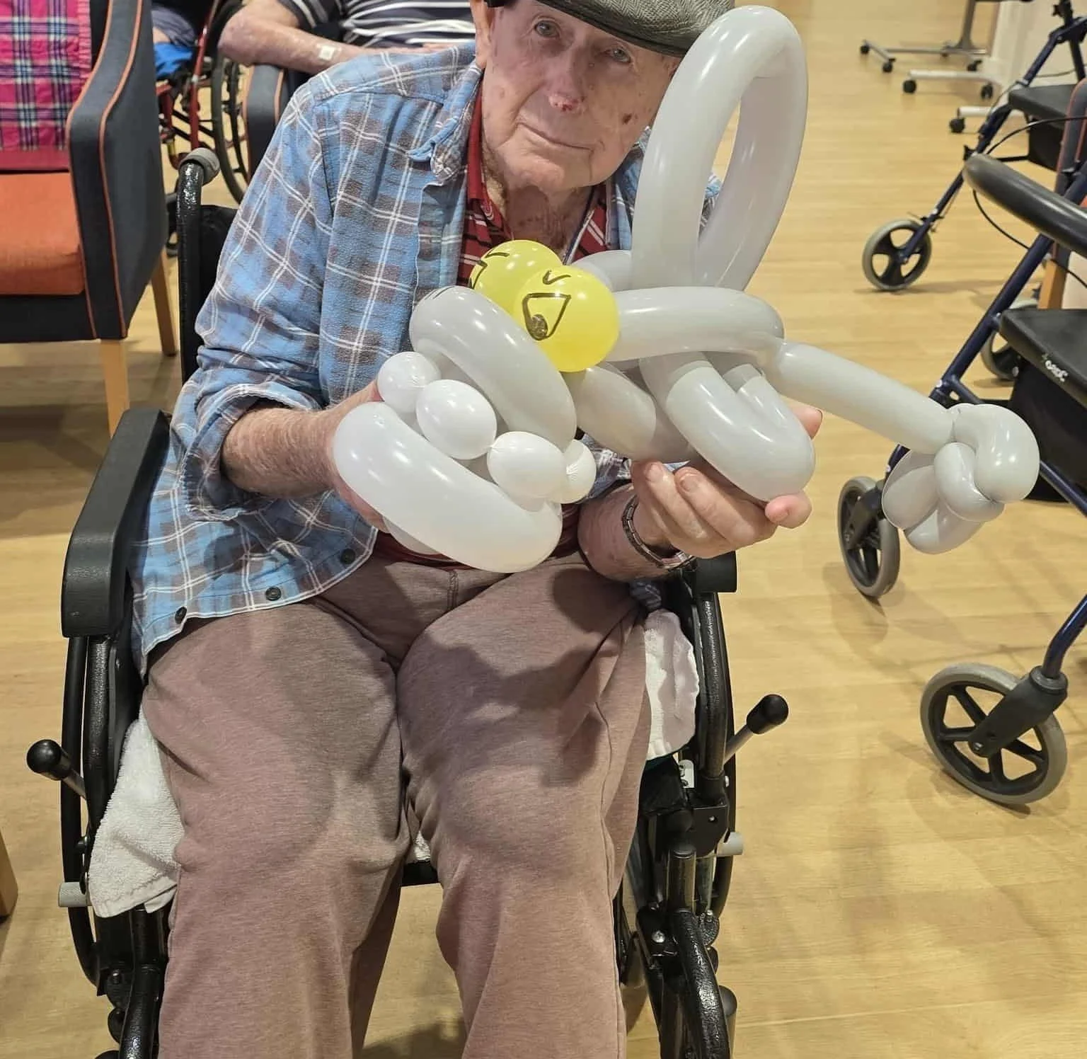 Balloon animal artist engaging residents during community visits and activities.