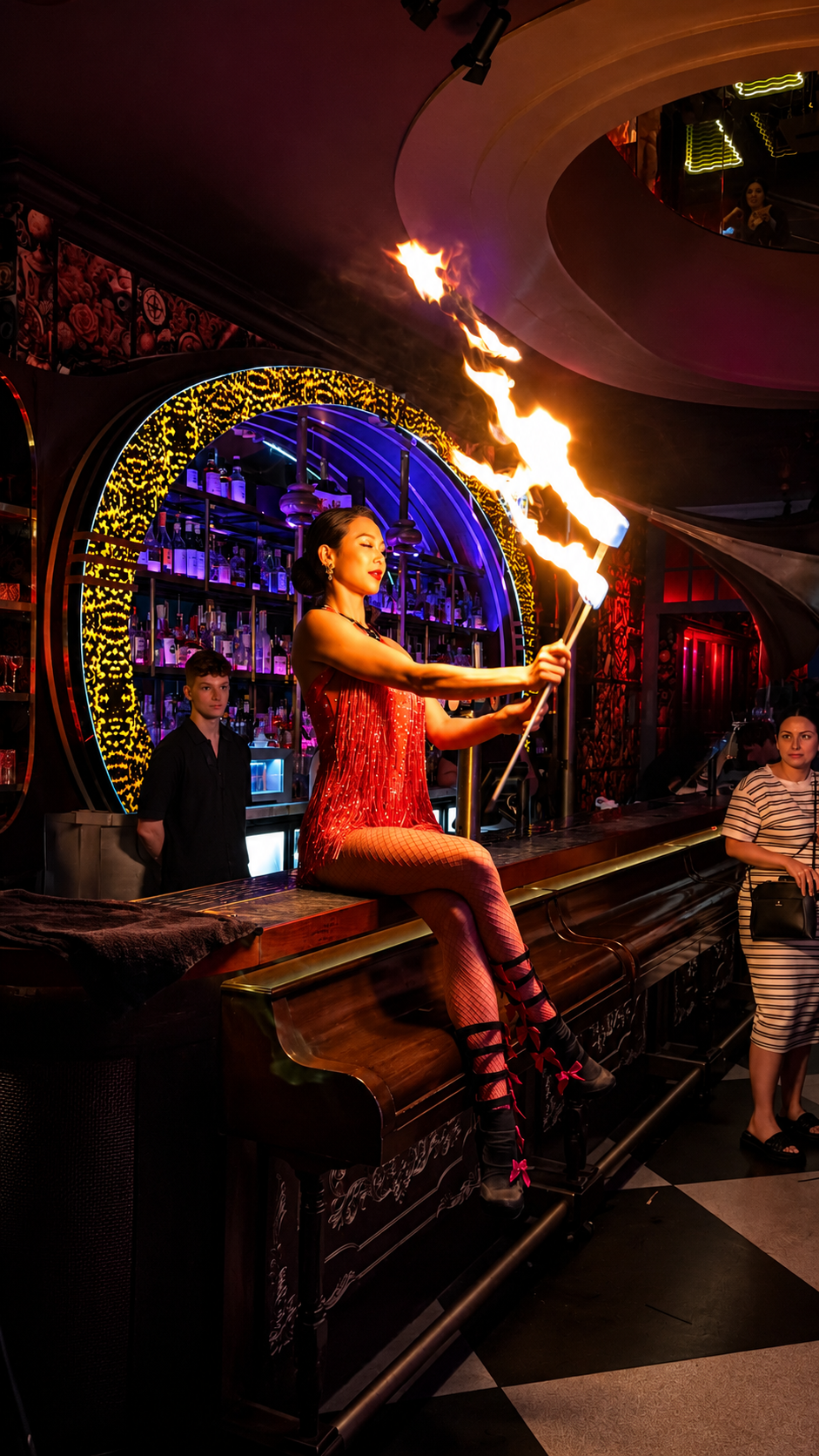 Red costume fire show performer at a luxury nightlife event.