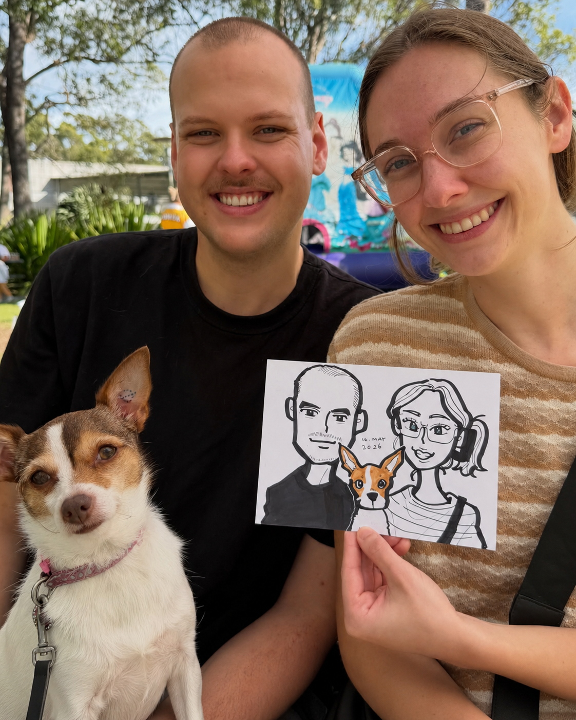 A couple posing with their dog and their custom live caricature portrait, including their pet in the drawing.