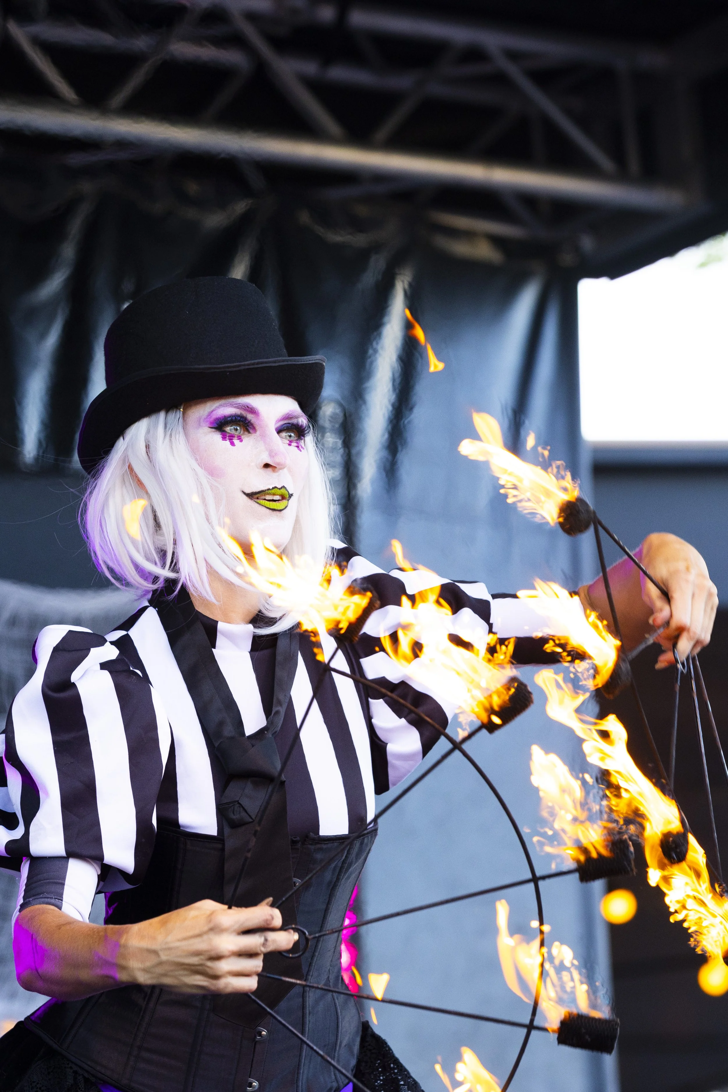 Halloween fire entertainer performing dramatic flame tricks on stage