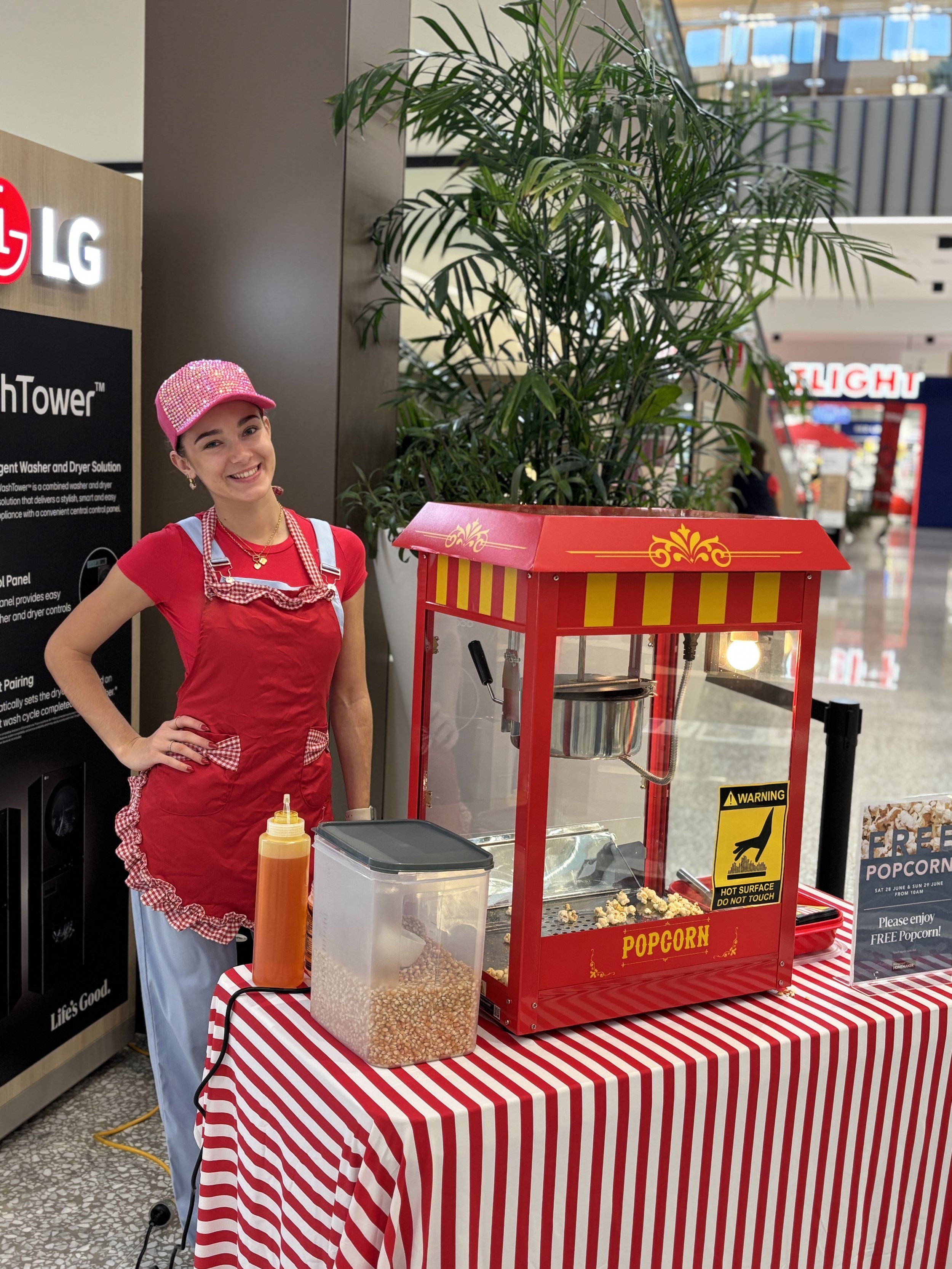 Brisbane event popcorn hire with operator in bright red outfit and classic popcorn machine