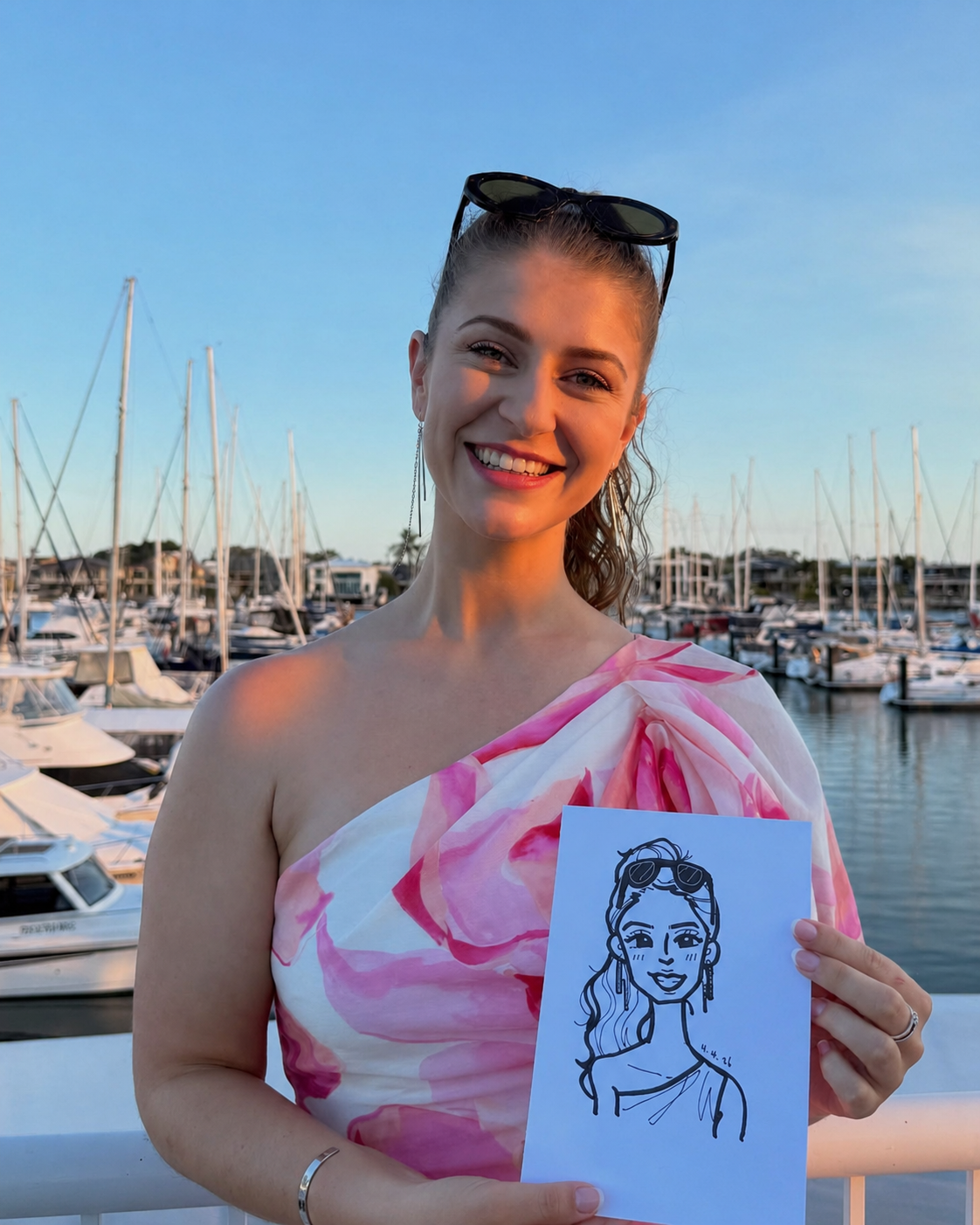 A guest holding her elegant live caricature portrait at a waterfront wedding or private celebration.
