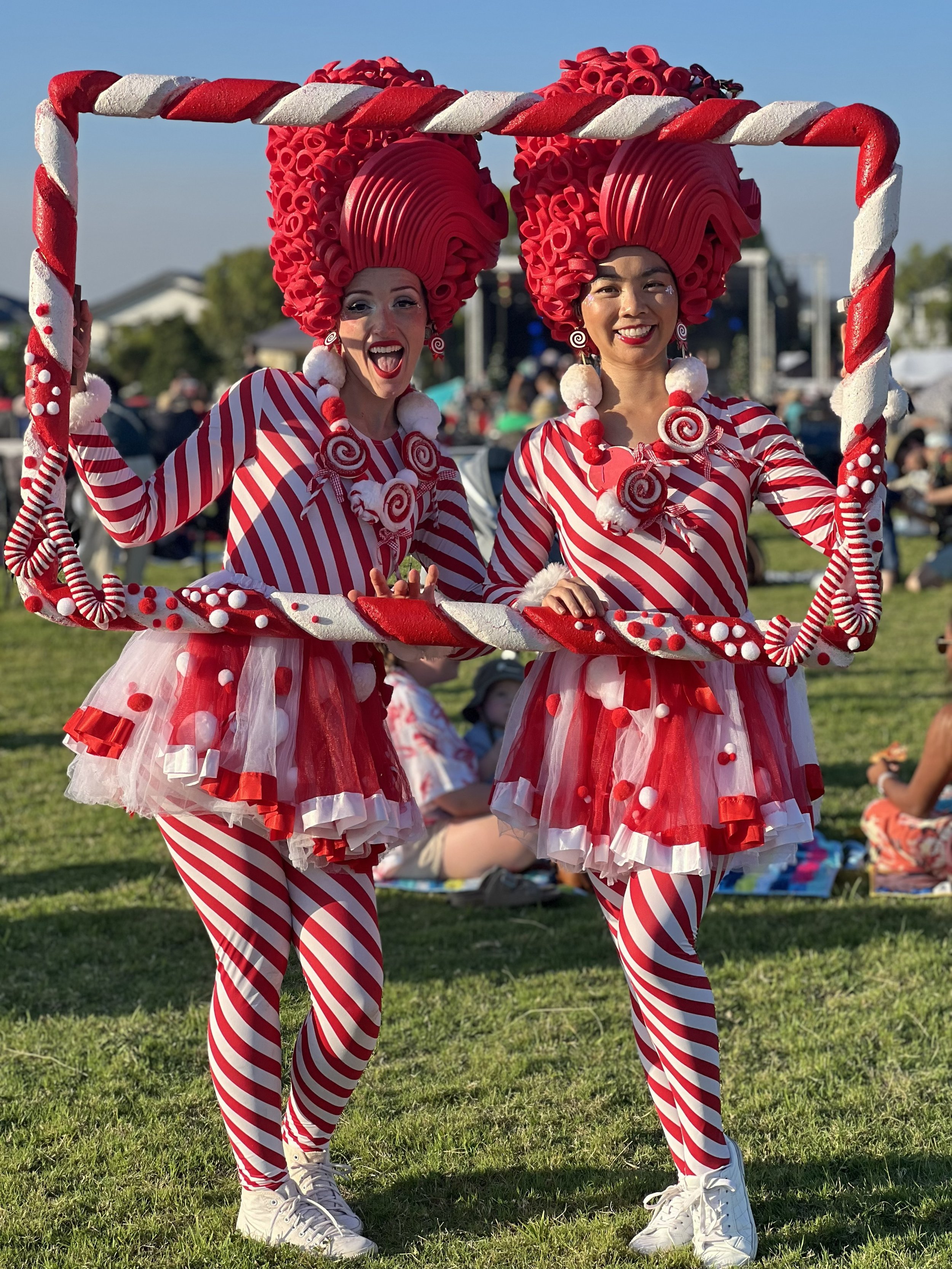 Christmas roving picture frame performer creating festive guest photos at holiday community celebration.