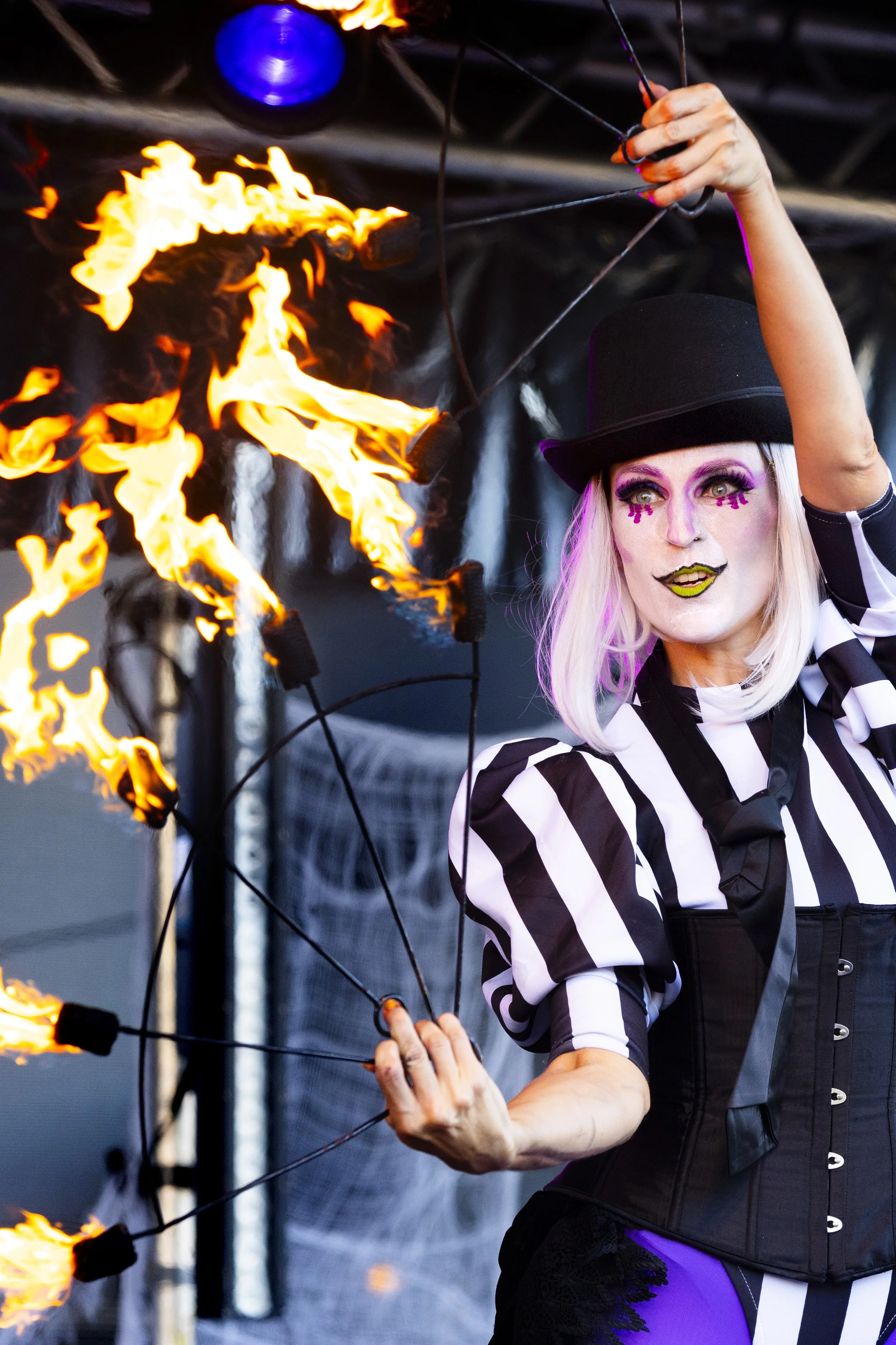Fire act performer engaging audience with flames and character theatrics