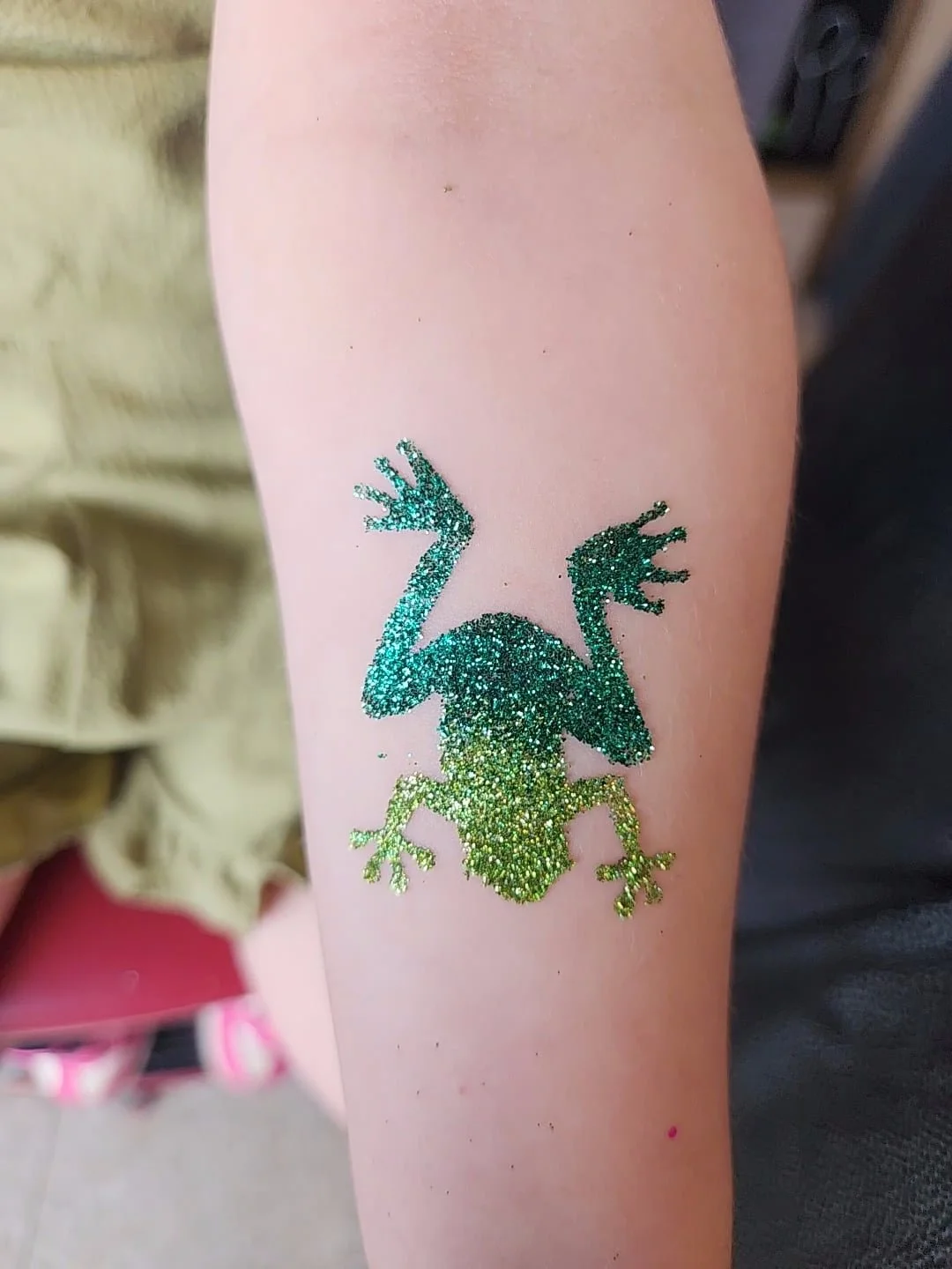 Popular glitter tattoo activity drawing crowds at Brisbane festivals and outdoor events.