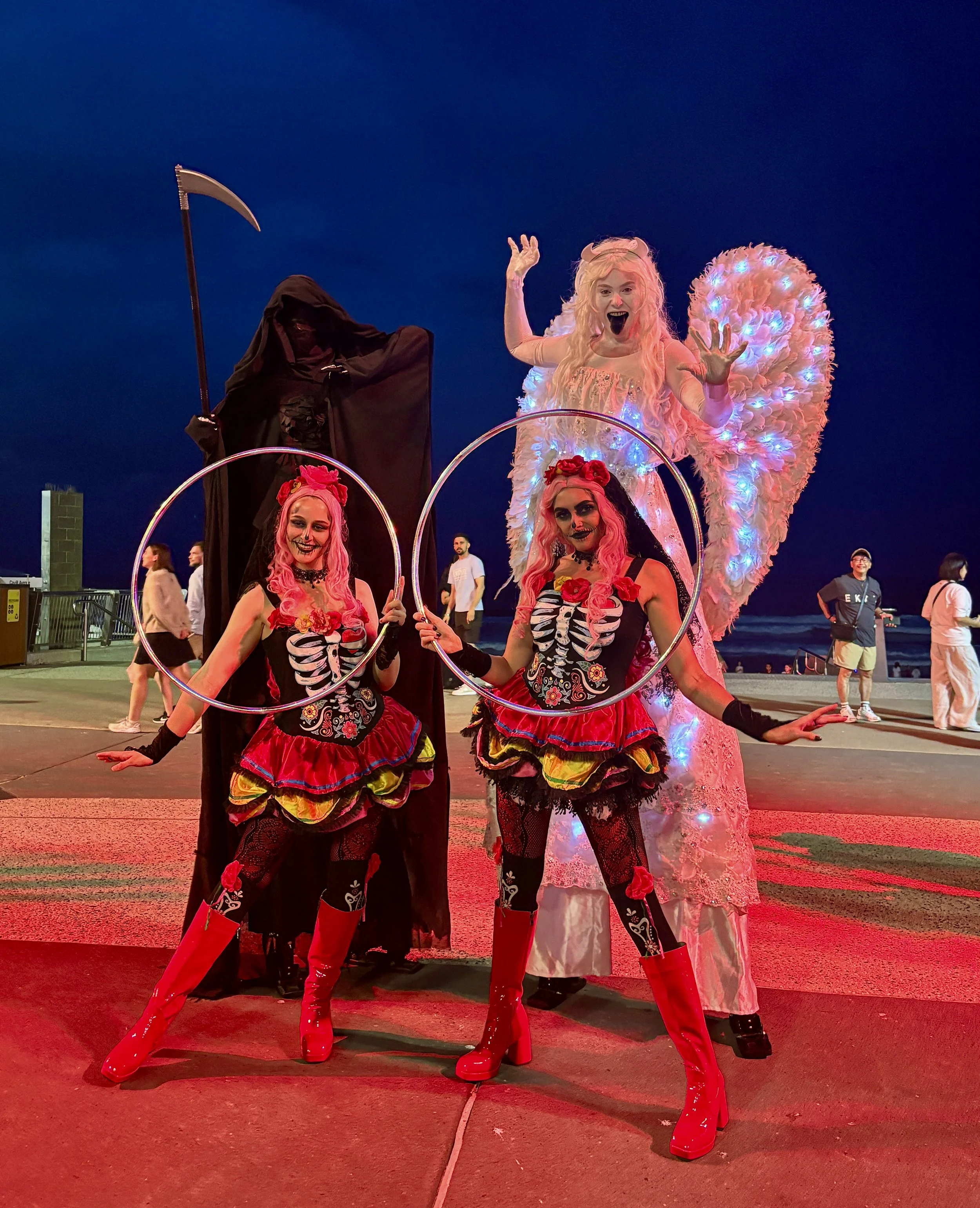 Dark reaper performer on stilts creating eerie atmosphere outdoors