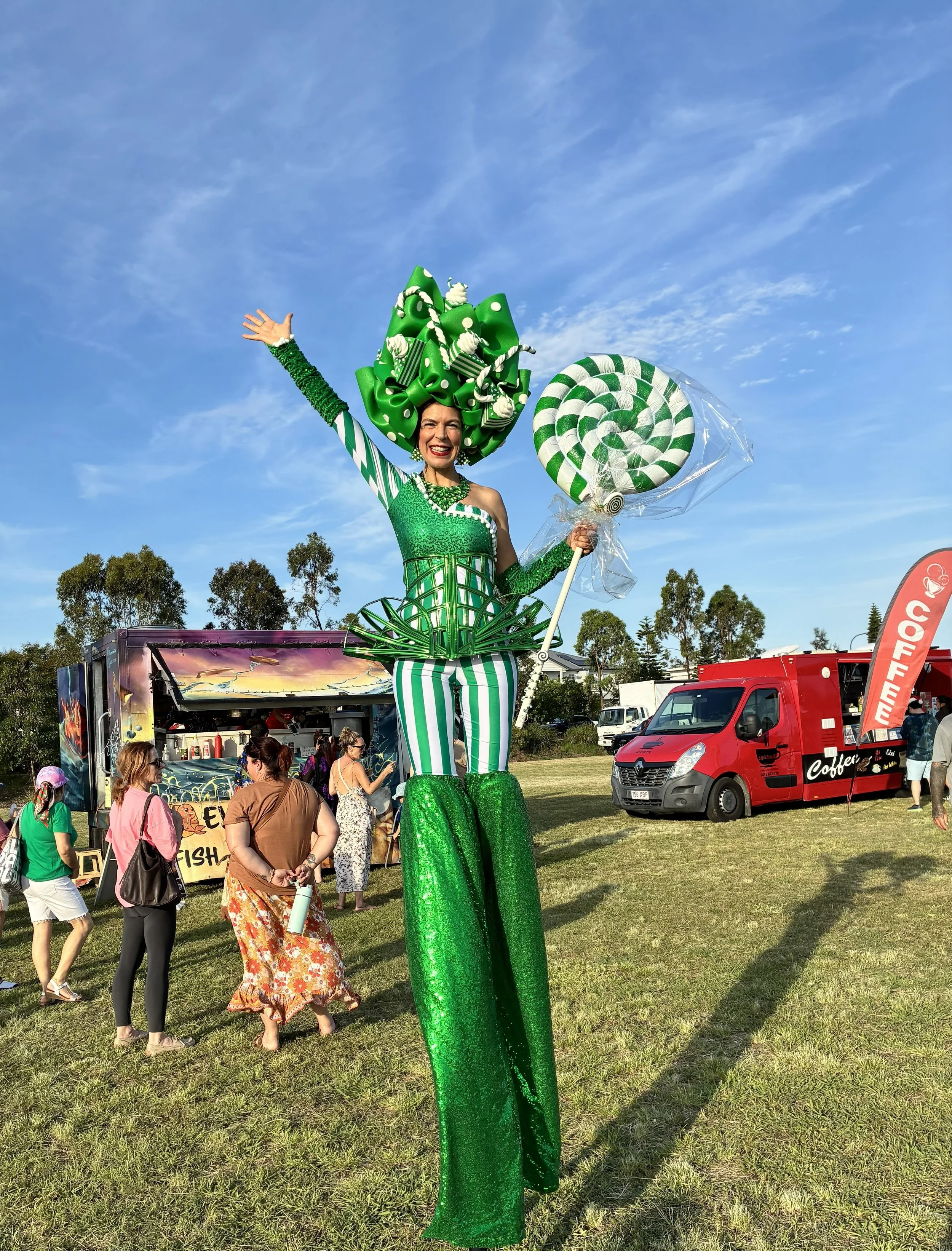Christmas-inspired green stilt walking entertainer at a festive outdoor activation.