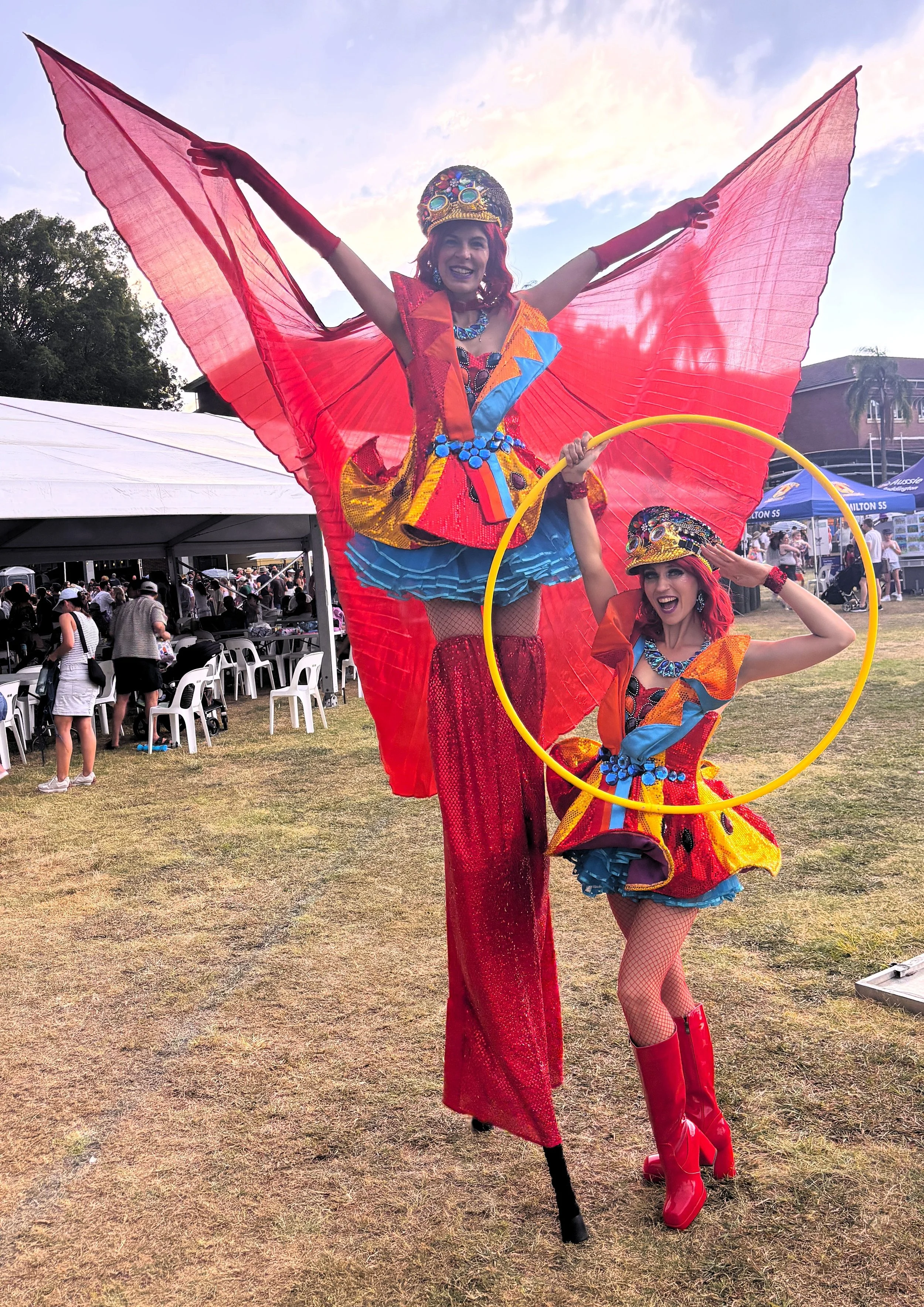 Red colourful matching stilts and hula hoop performers