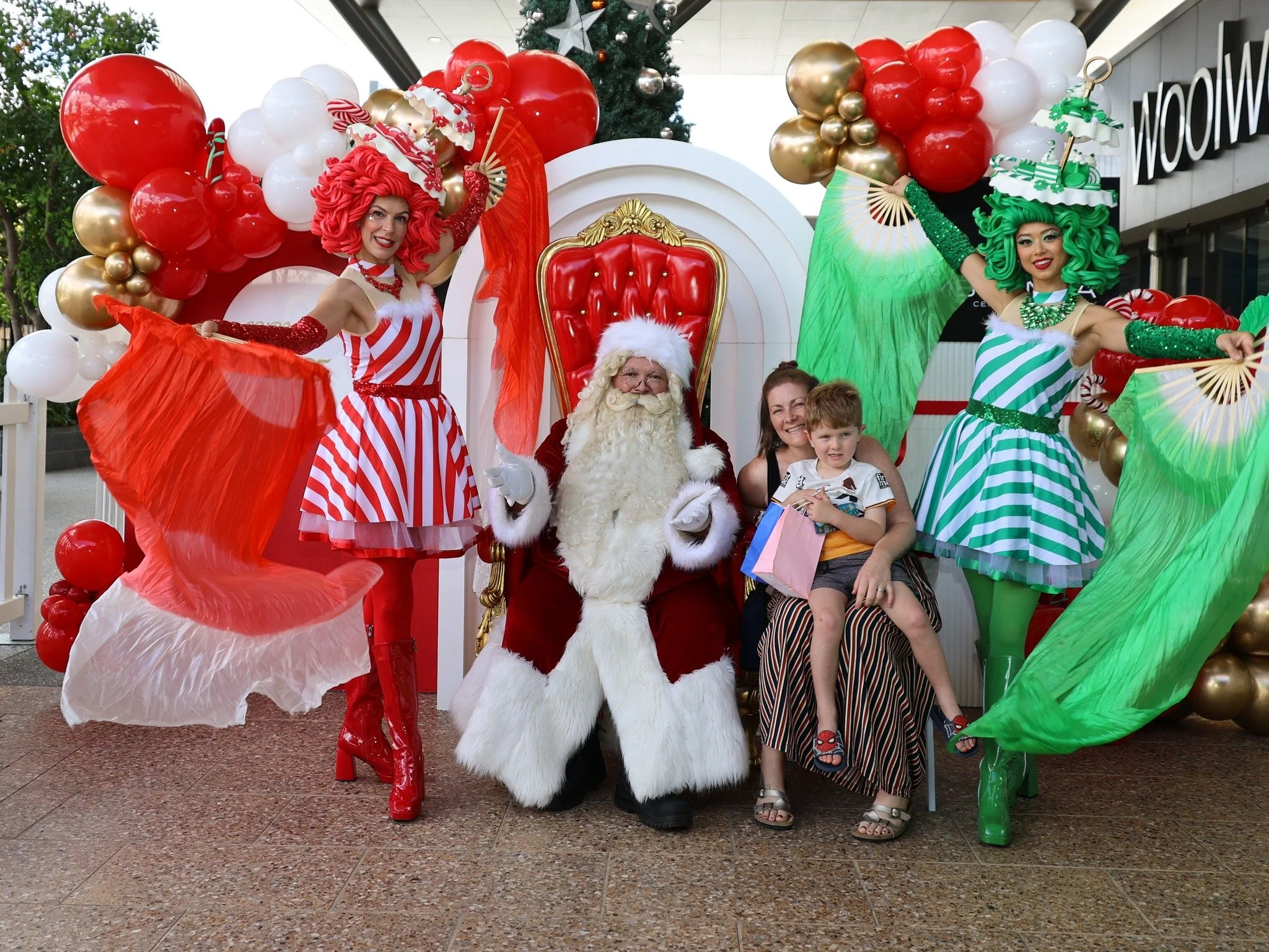 Santa photo experience with candy cane performers creating festive family memories at Chermside shopping centre.