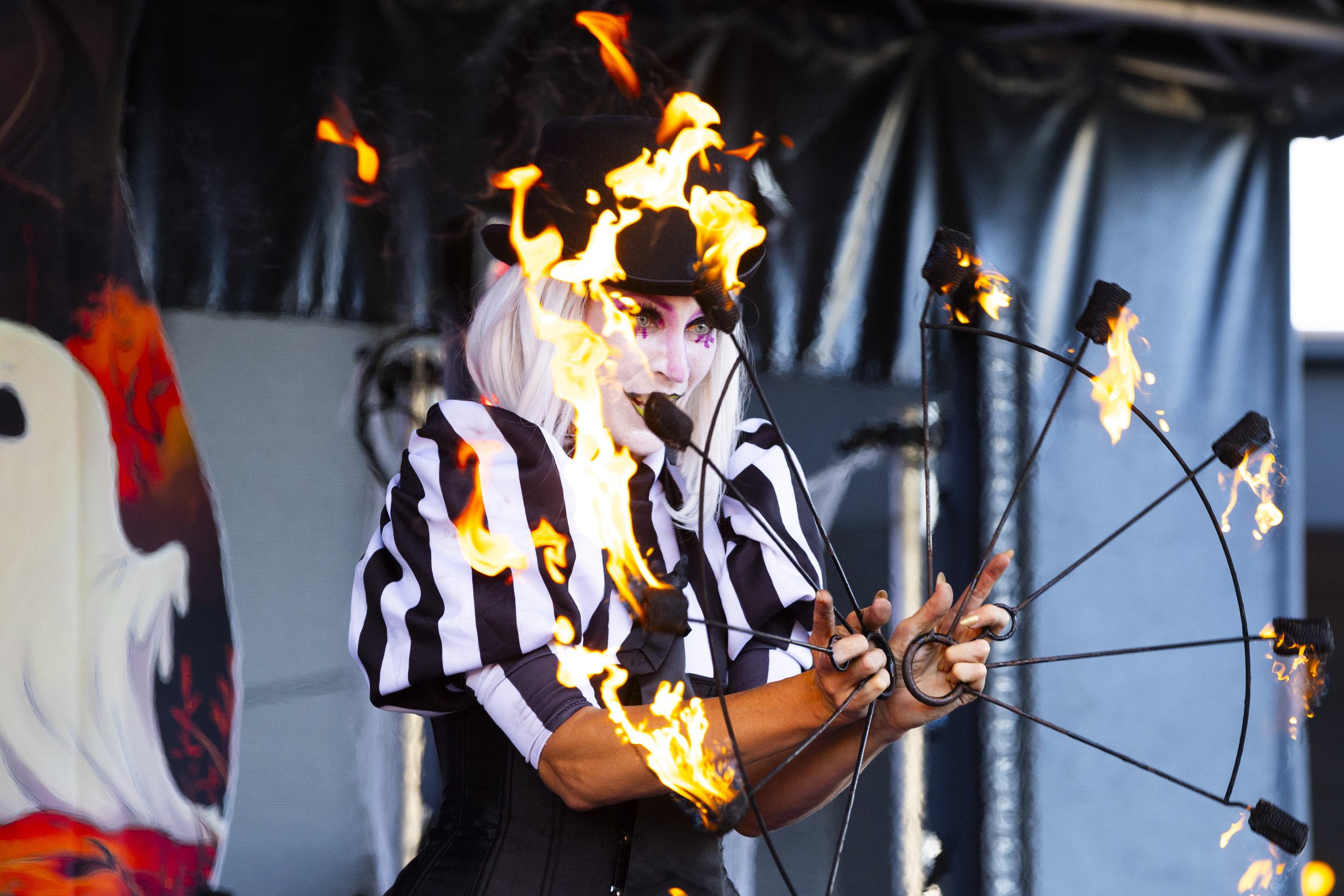 Fire illusion performer in black and purple costume at night event