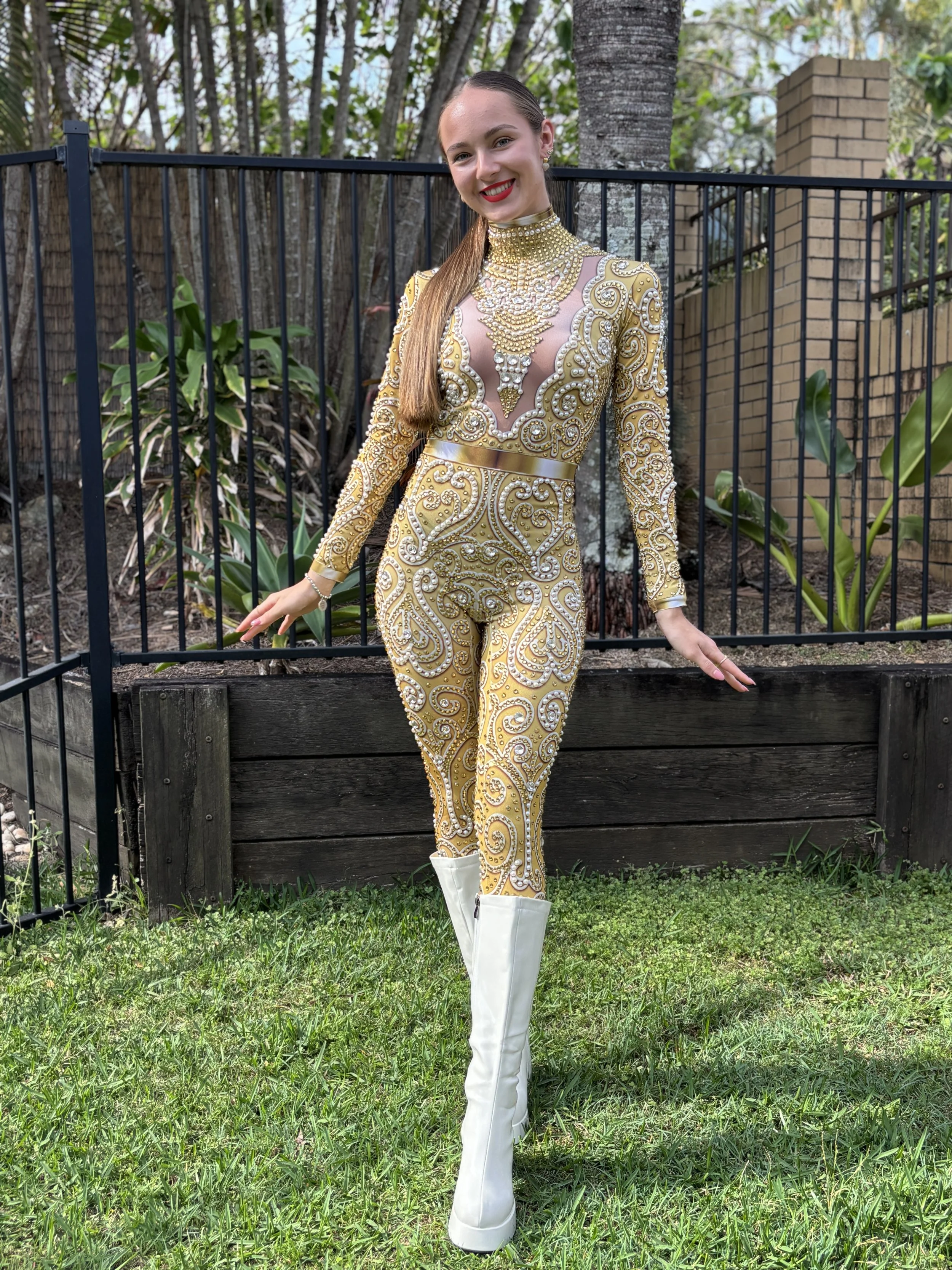 woman posing in an ornate gold costume with decorative patterns.